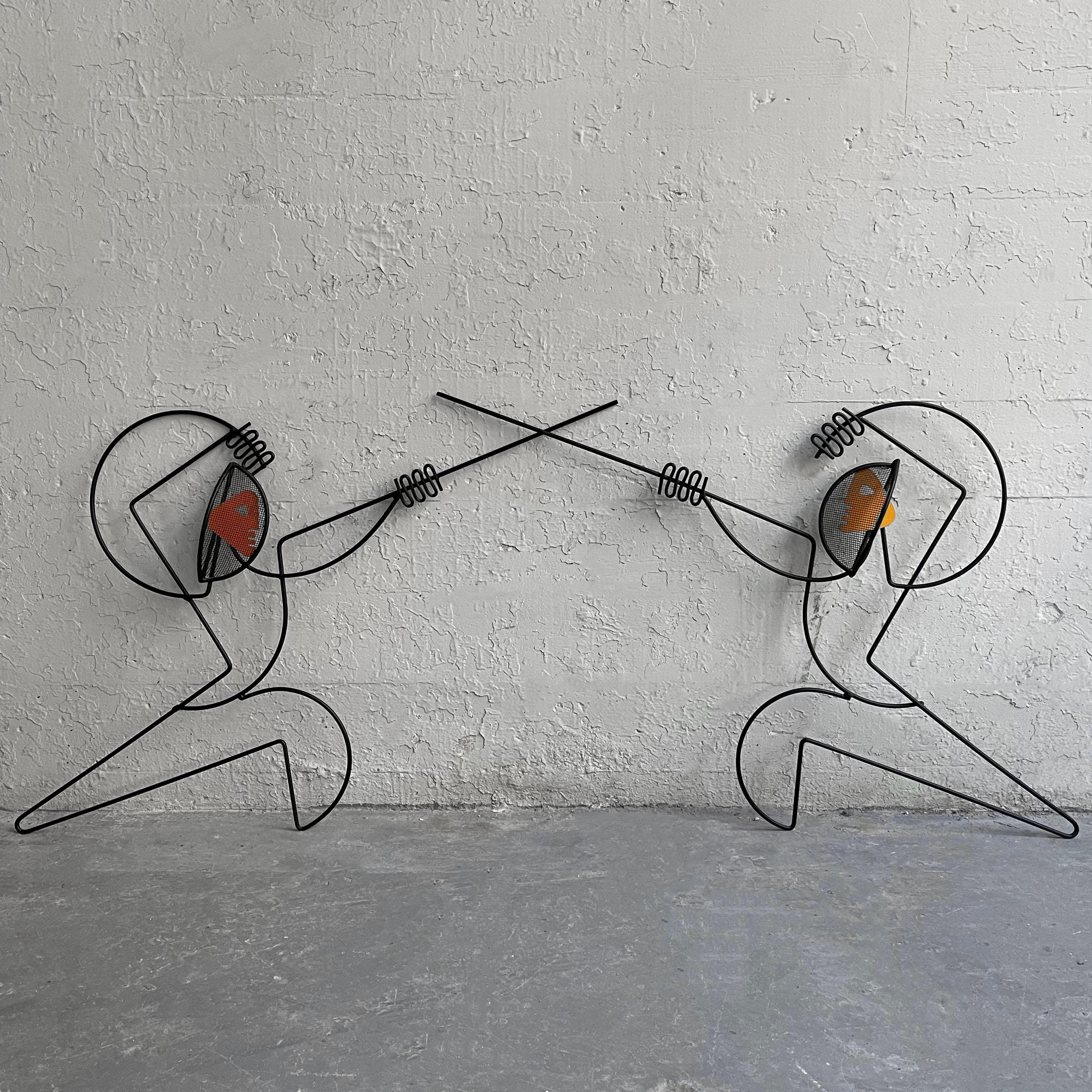 Pair of Mid-Century Modern, wrought iron, wall sculptures by Frederick Weinberg depicting fencers in engarde stance.