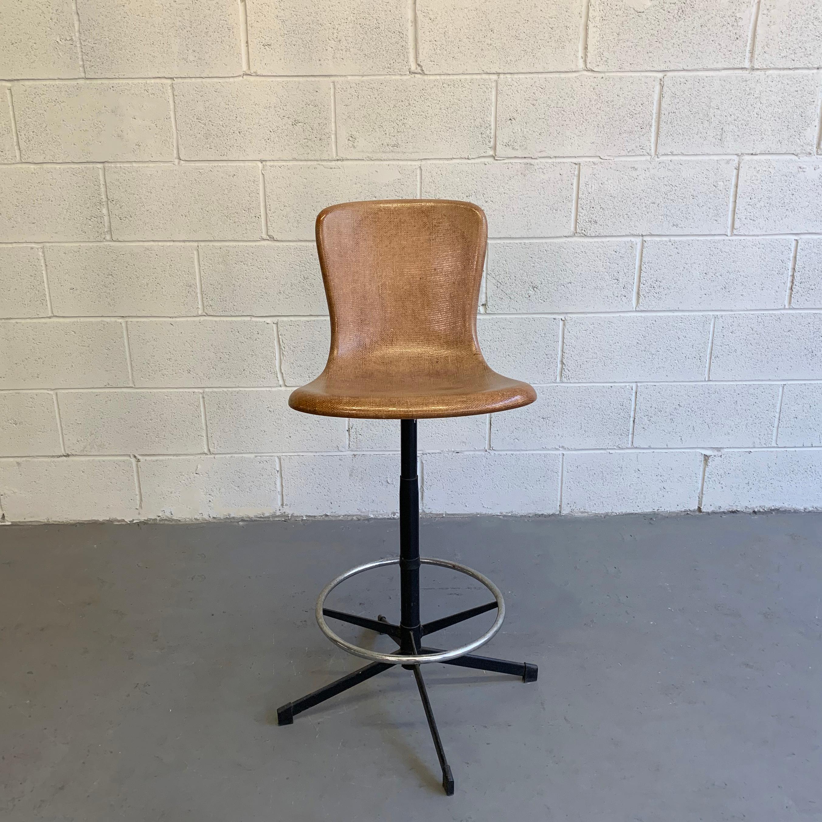 Tall, Mid-Century Modern stool by Cosco features a 17 inch wide, tan grasscloth, fiberglass shell on a steel pedestal base with footrest.
