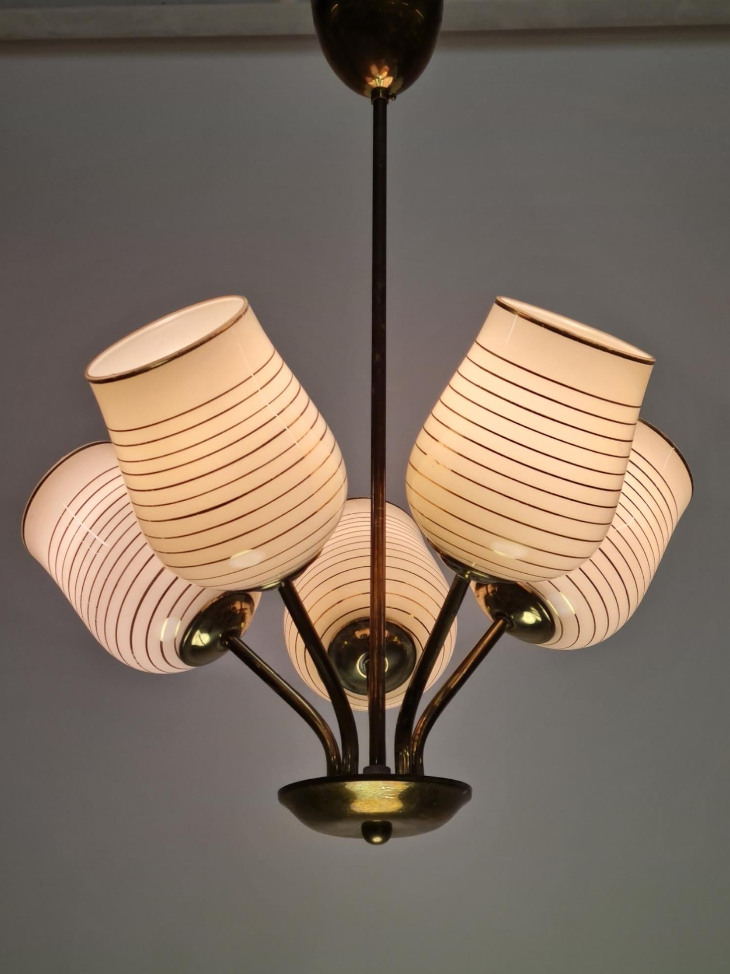 A 1950s Finnish design ceiling lamp with five light sources. This lamp has some similarities to Paavo Tynell lighting fixtures, but as not everyone could afford Tynells, even back then, these came to cover the high demand on such lights. The lamp is