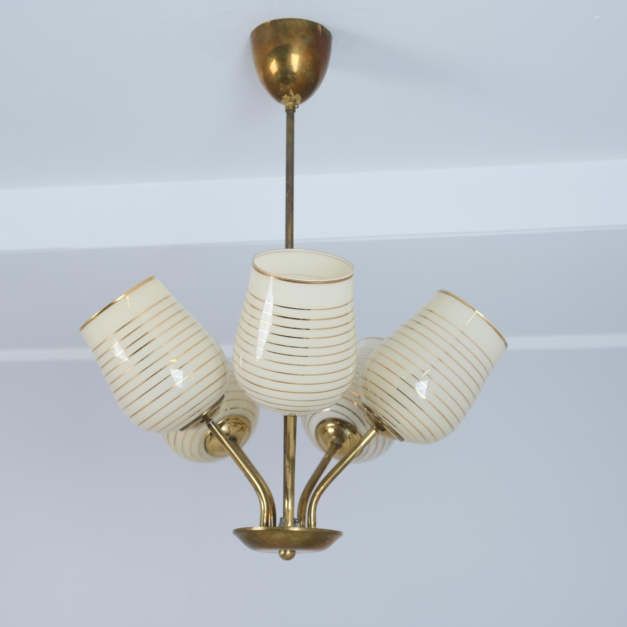 A 1950s Finnish design ceiling lamp with five light sources. This lamp has some similarities to Paavo Tynell lighting fixtures, but as not everyone could afford Tynells, even back then, these came to cover the high demand on such lights. The lamp is