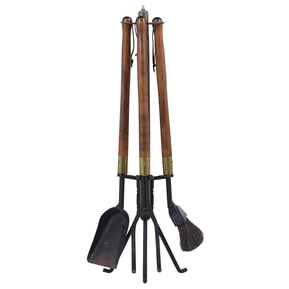 Mid-Century Modern fireplace tools handcrafted out of wood and iron combination. This set features a streamlined stand, poker, tongs, shovel, broom, and log holder.
 