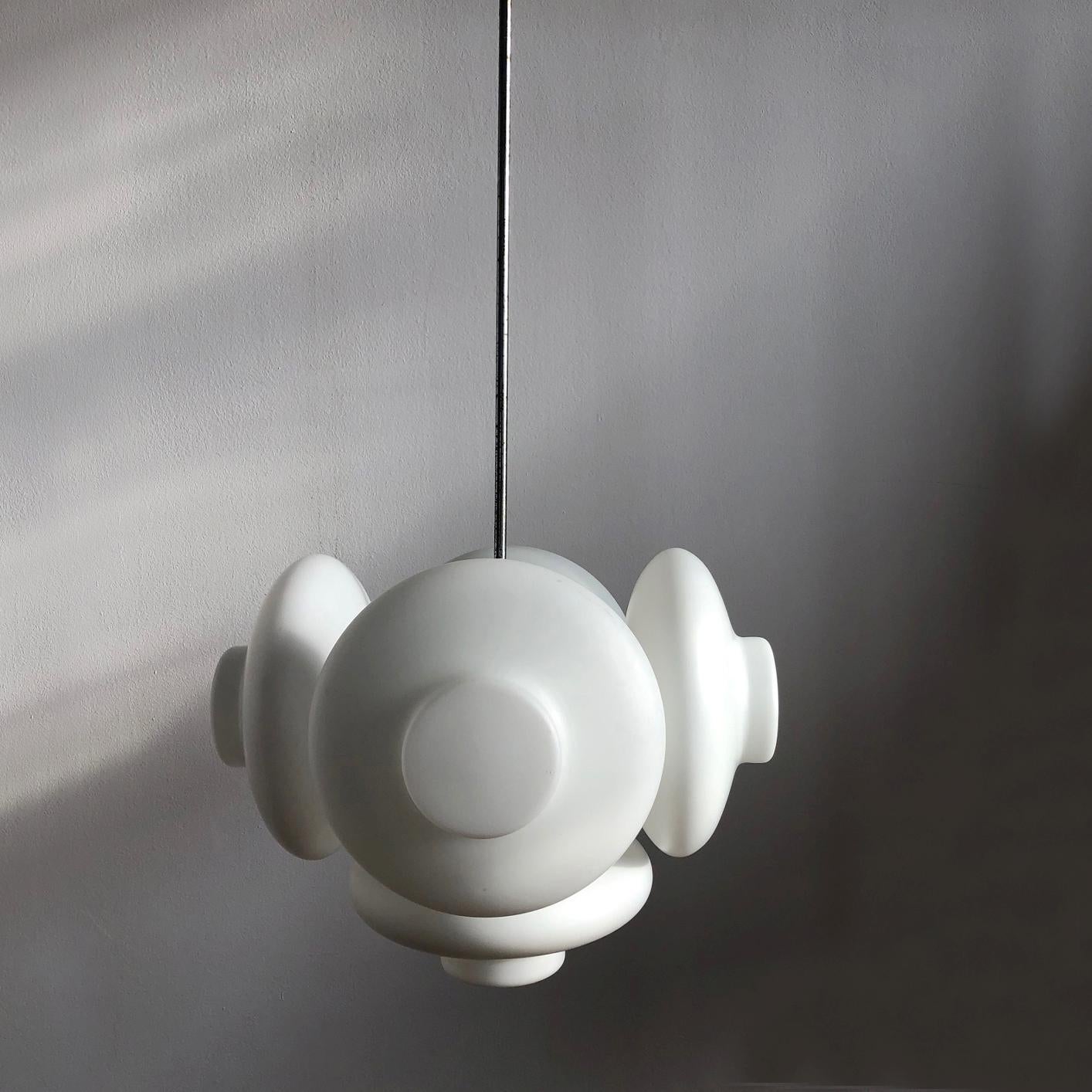 Unusual hanging lamp signed Napako. Five lampshades are made of milk glass and gives warm diffused light. The lamp is rewired. The length of the rod can be customized. 