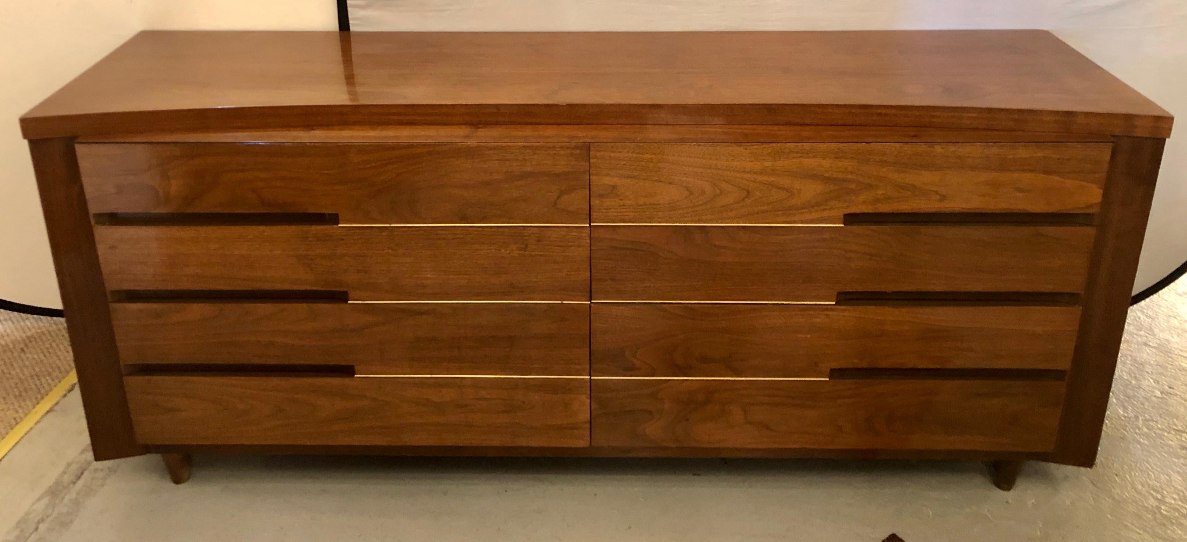 Mid-Century Modern flame mahogany sideboard, server or dresser with brass mounts is unsigned in the manner of Paul McCobb. This stunning one of a kind chest is in its original finish having a finely polished case of double four by four drawers each