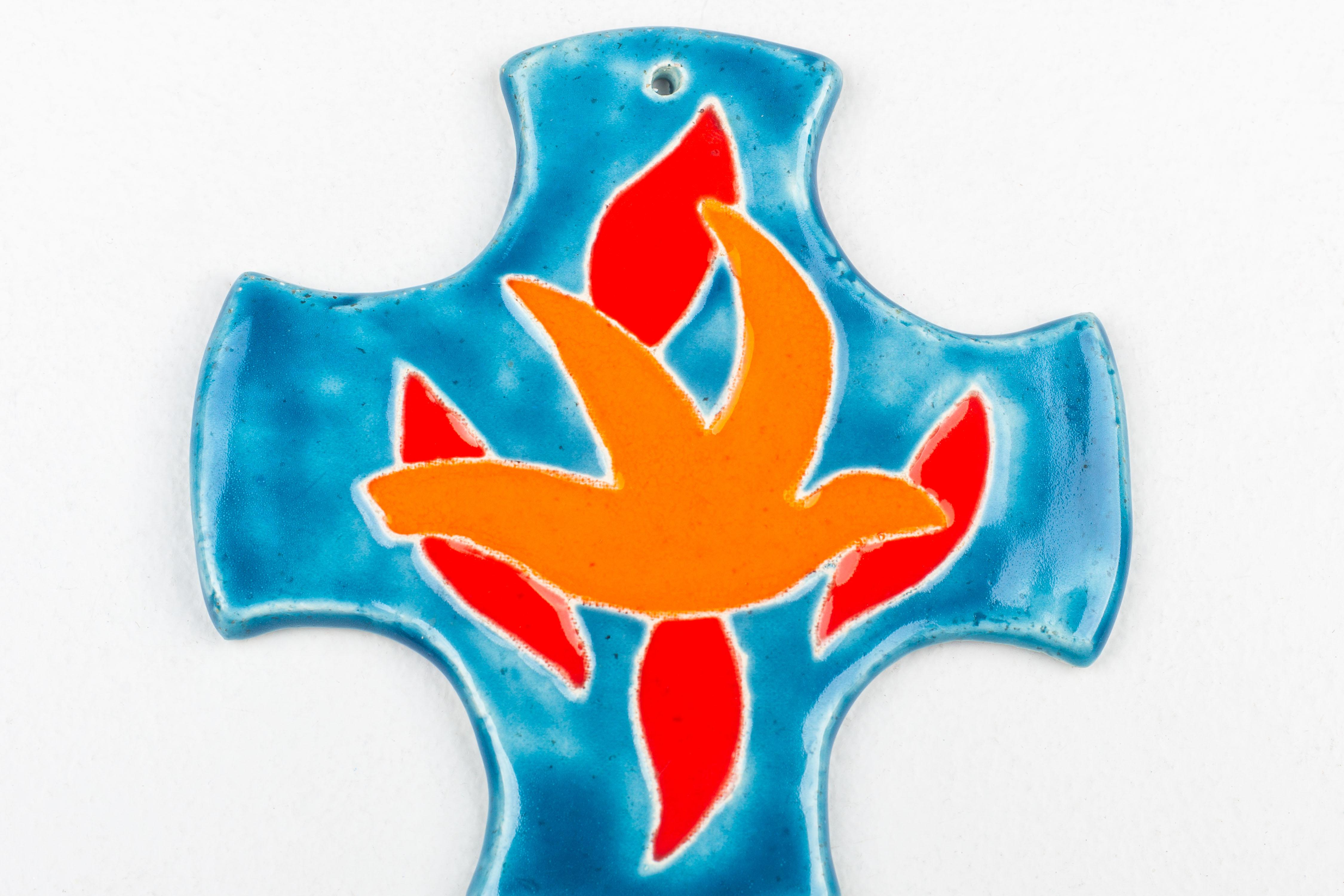 This ceramic cross is a dynamic representation of mid-century modern artistry, crafted by the skilled hands of a studio pottery artist in Europe. The cross's design features a central flame motif, executed in a bold orange-red glaze that symbolizes