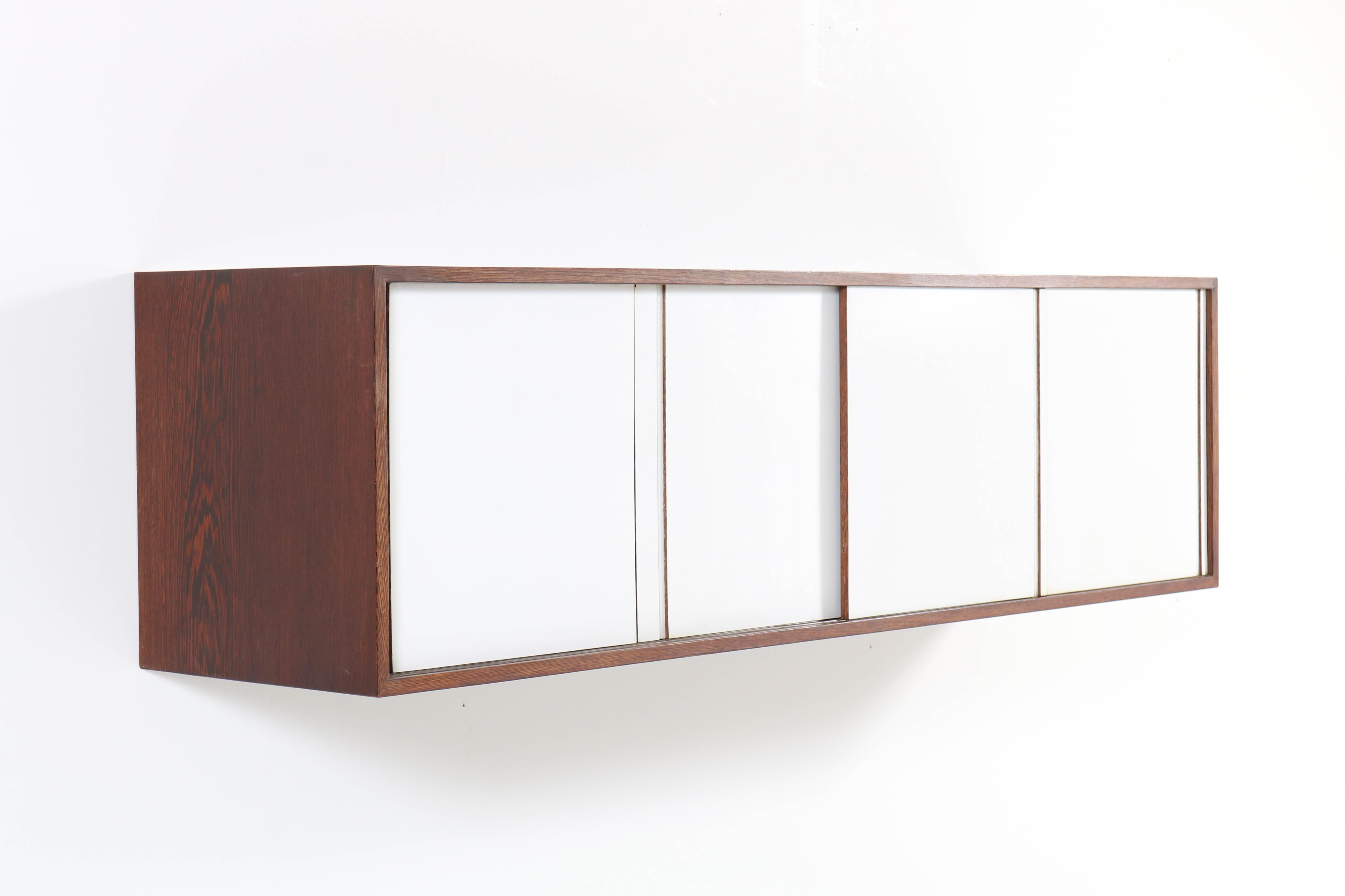 Stunning and rare Mid-Century Modern floating sideboard or credenza.
Design by Martin Visser for 't Spectrum.
Striking Dutch design from the 1960s.
Wengé with original lacquered sliding doors.
In good original condition with minor wear