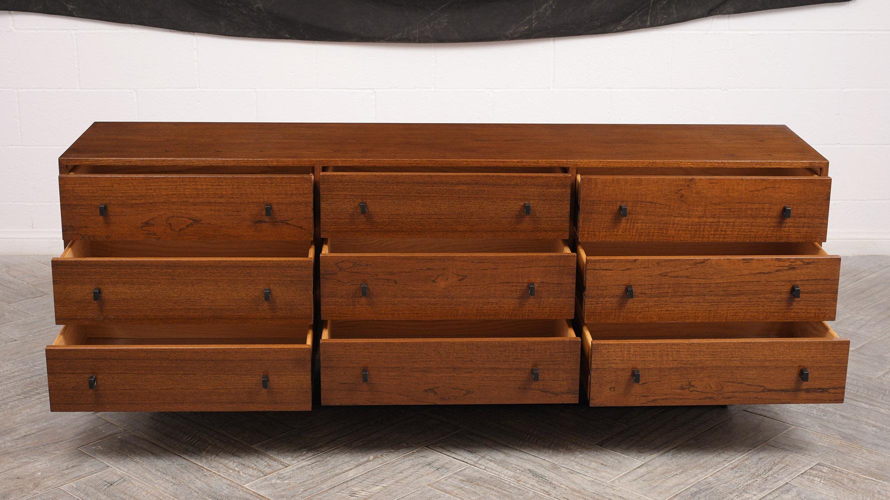 This is a lovely spacious nine-drawer dresser. The dresser has been completely restored. Solid walnut wood construction with its original walnut finish. Features nine drawers that open and close with ease with dual black brass design pulls. Finished