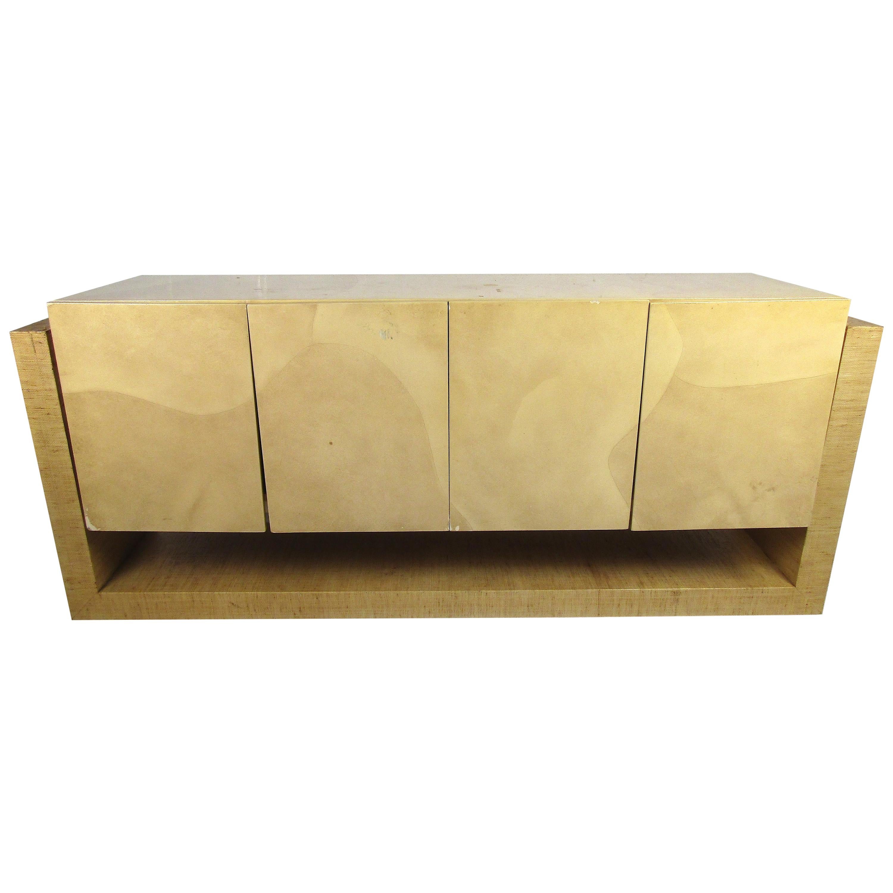 A beautiful vintage modern sideboard with a grasscloth base holding a lacquered goatskin credenza. A unique and efficient design in the style of Karl Springer. The unusual design offers an additional lower shelf for storage. Four cabinet doors hide