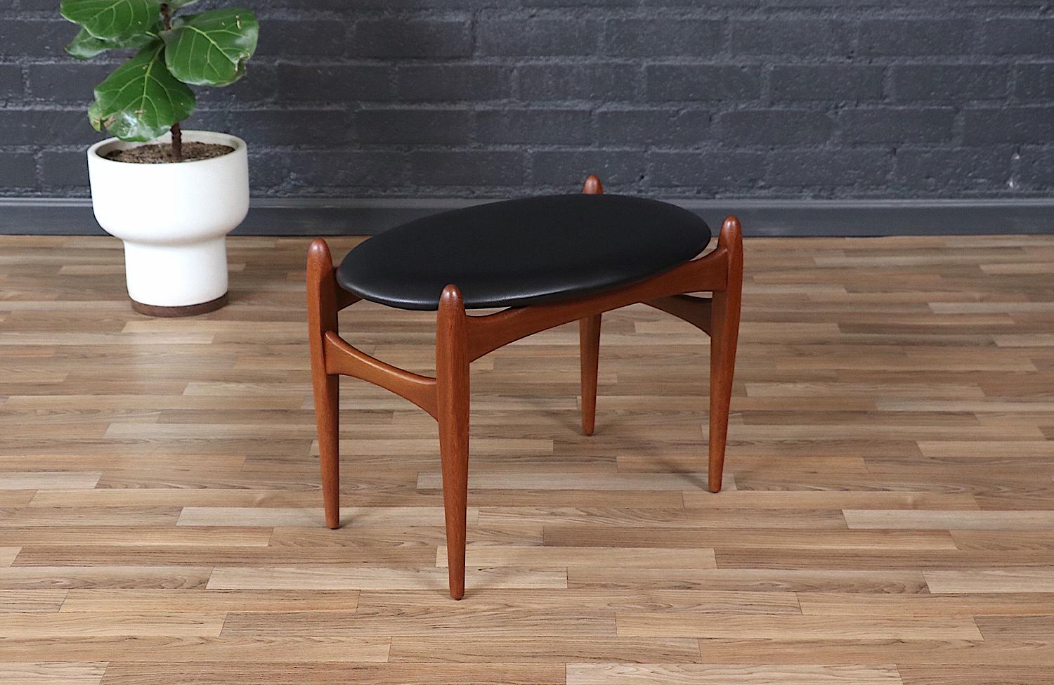 This elegant Mid-Century Modern stool by Elliots of Newbury exemplifies the timeless craftsmanship of British furniture design. Constructed from rich African teak, the frame showcases graceful curves and sculptural joinery, emphasizing the natural