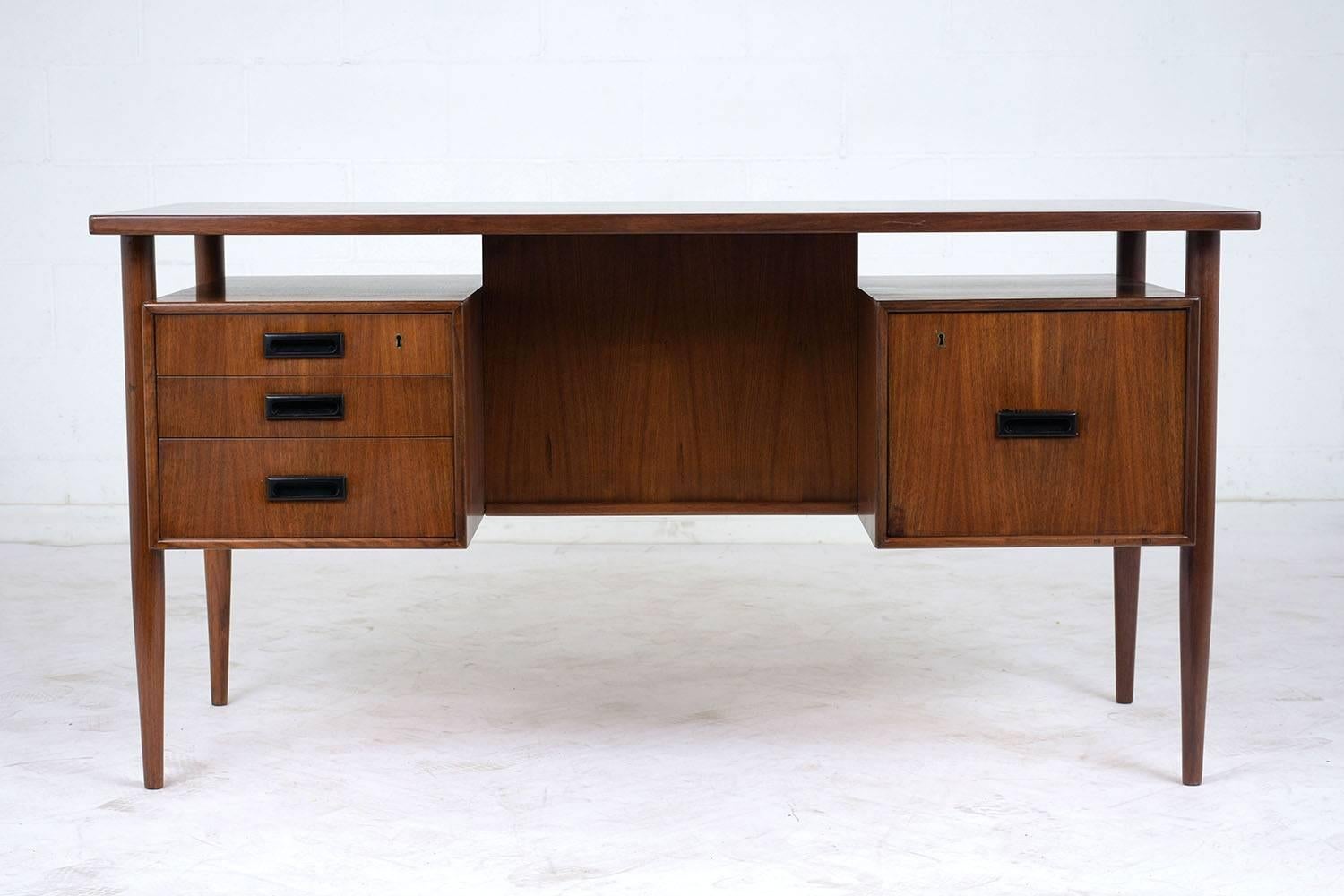 This Mid-Century Modern style floating desk is made from teak wood stained a rich walnut color with a lacquered finish, 1960s. On either side there are two storage cubes with drawers on the front and open shelving finished in black on the back. The