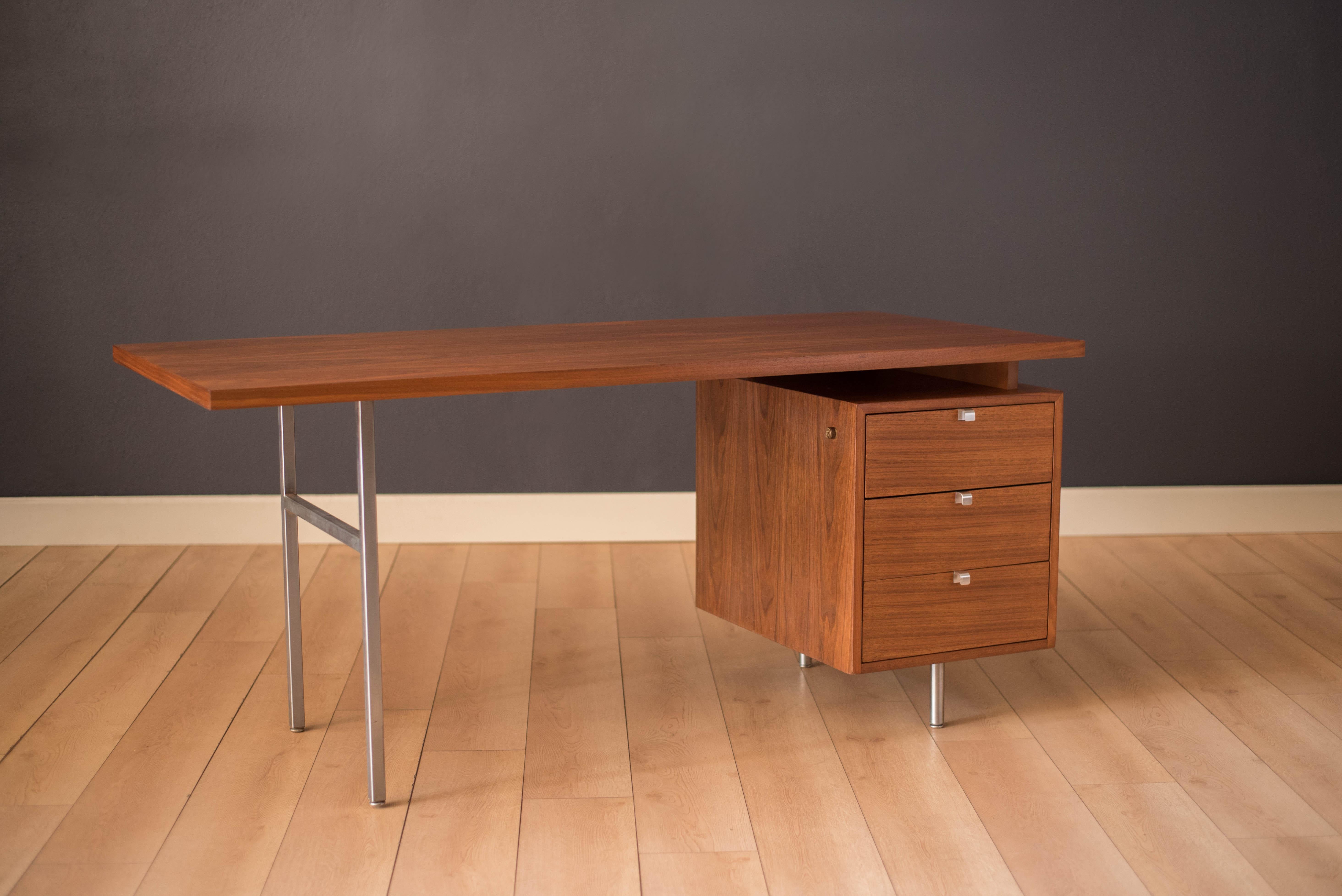 Vintage executive desk designed by George Nelson for Herman Miller, circa 1960s. This piece features a floating walnut top that offers plenty of display space supported by steel legs. Includes a bank of three storage drawers accented with brushed