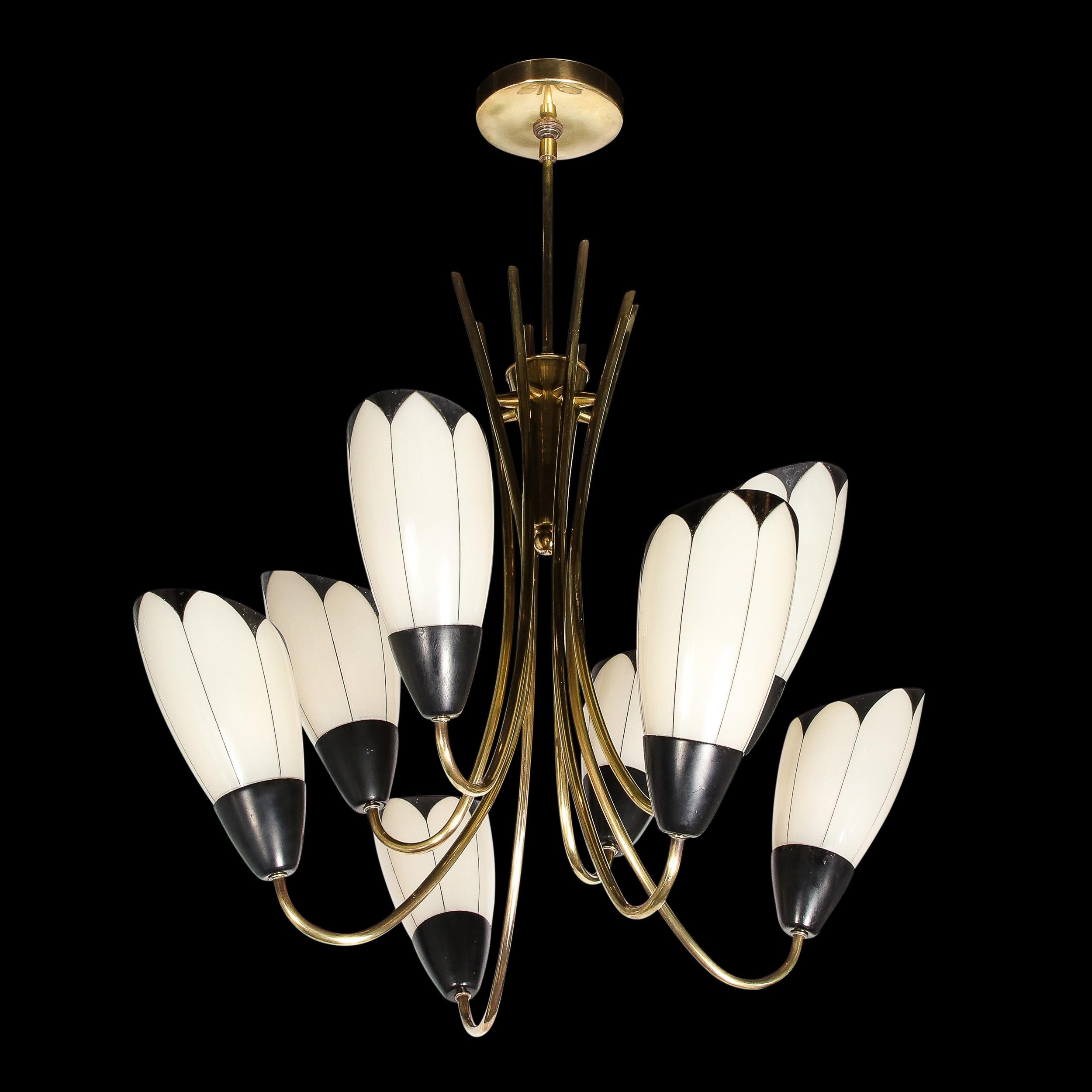 This beautiful Mid-Century Modern chandelier was realized in France circa 1950. It offers eight oblong elongated milk glass shades replete with hand embellished demilune pointed motifs in black enamel that transition into fine striations in the same