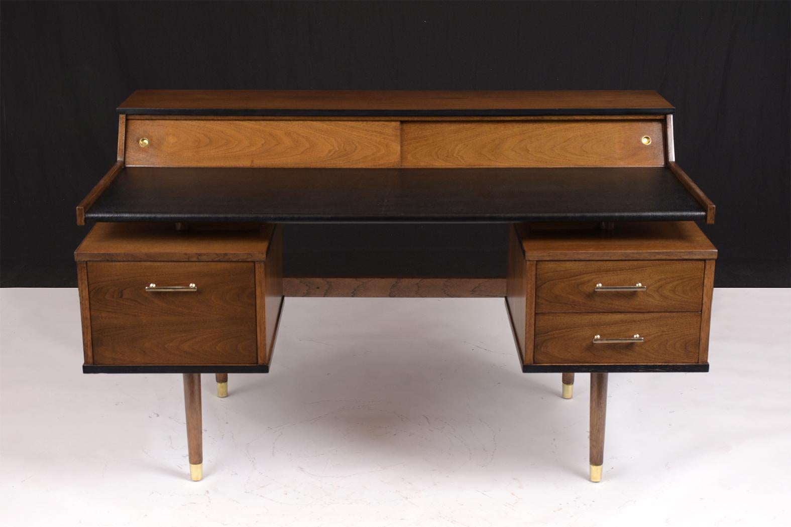 This Mid Century Modern Desk, Model K80 by John Van Koert for Drexel is made out of walnut wood and has been professionally restored. This Floating Desk has been stained a new dark walnut color with a lacquered finish and flat moldings finished in