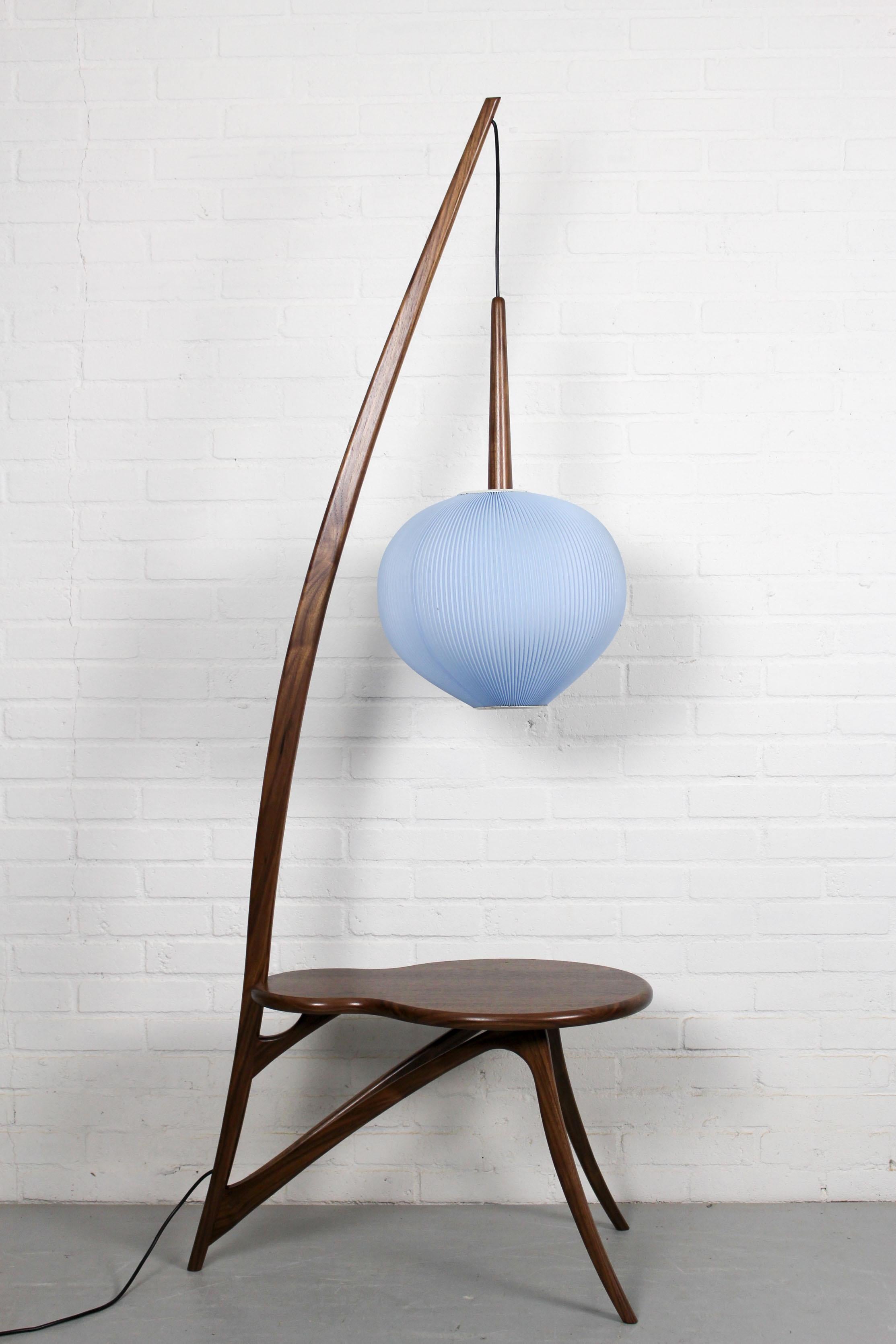This mid century plastic blue lampshade has a beautiful color and shape. The lamp is completed with a new organically shaped american nut foot with attached table so it can be used as standing floor lamp.The lamp itself is in original and good