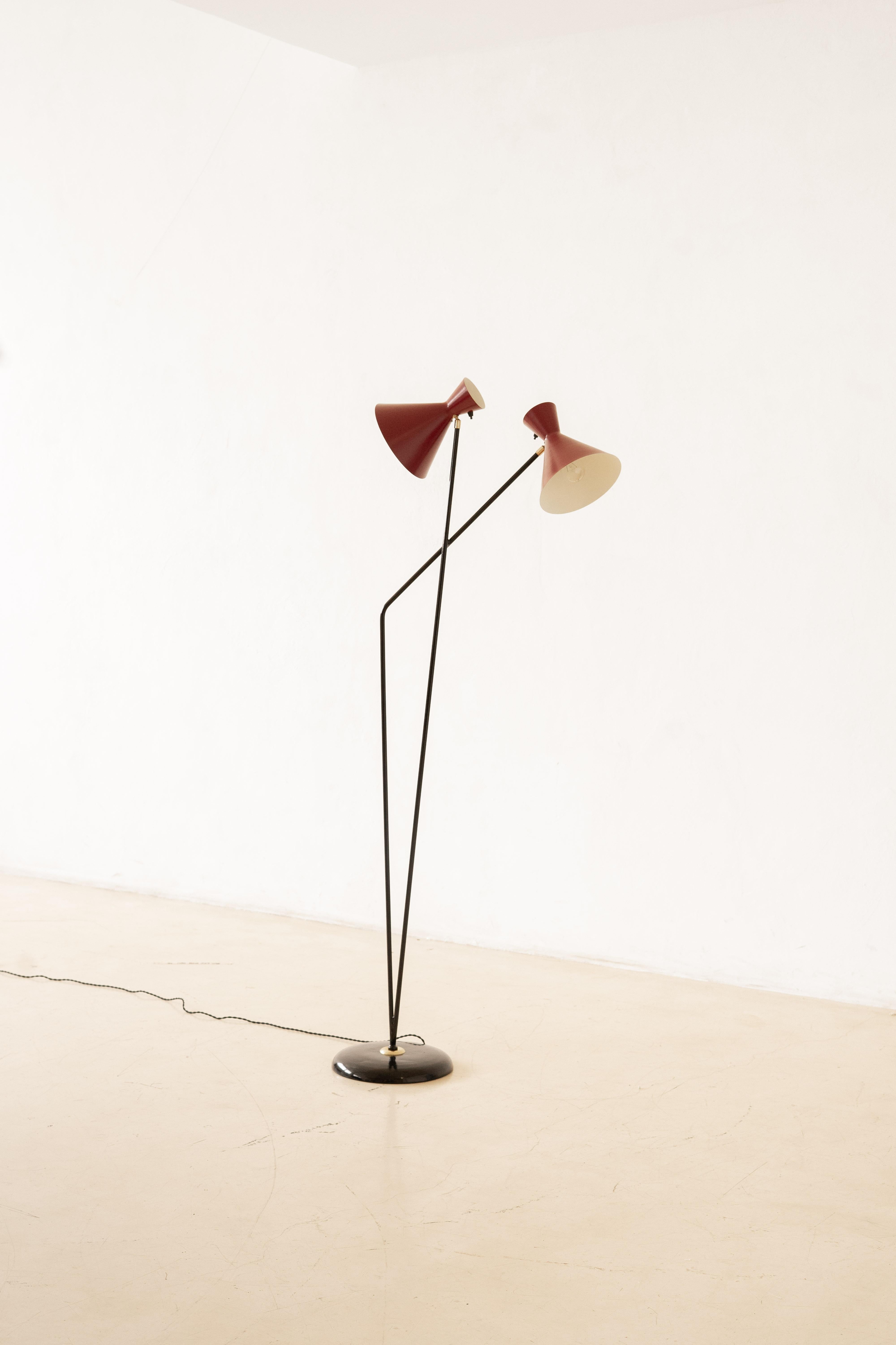 Lampada da terra in stile italiano con base in ghisa e copertura in alluminio verniciato nero lucido. La struttura verticale è composta da aste di ferro con la stessa finitura nera lucida, che sostengono due paralumi regolabili, ciascuno con una