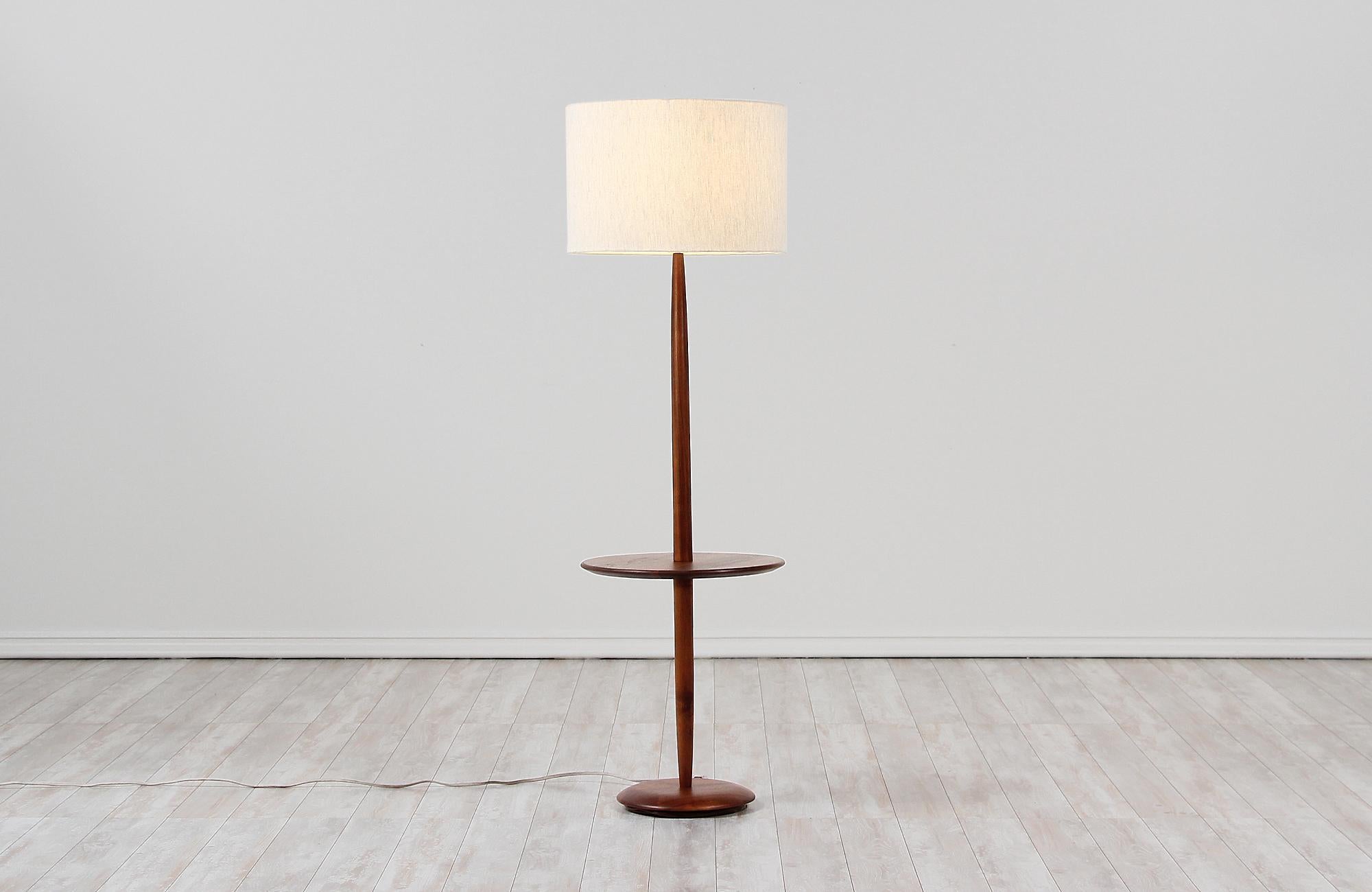 Modern floor lamp designed and manufactured by Laurel Lamp Co. in the United States, circa 1960s. This sleek, Minimalist design features a tall walnut wood body with a circular slate table surface and weighted base that gives stability and style to