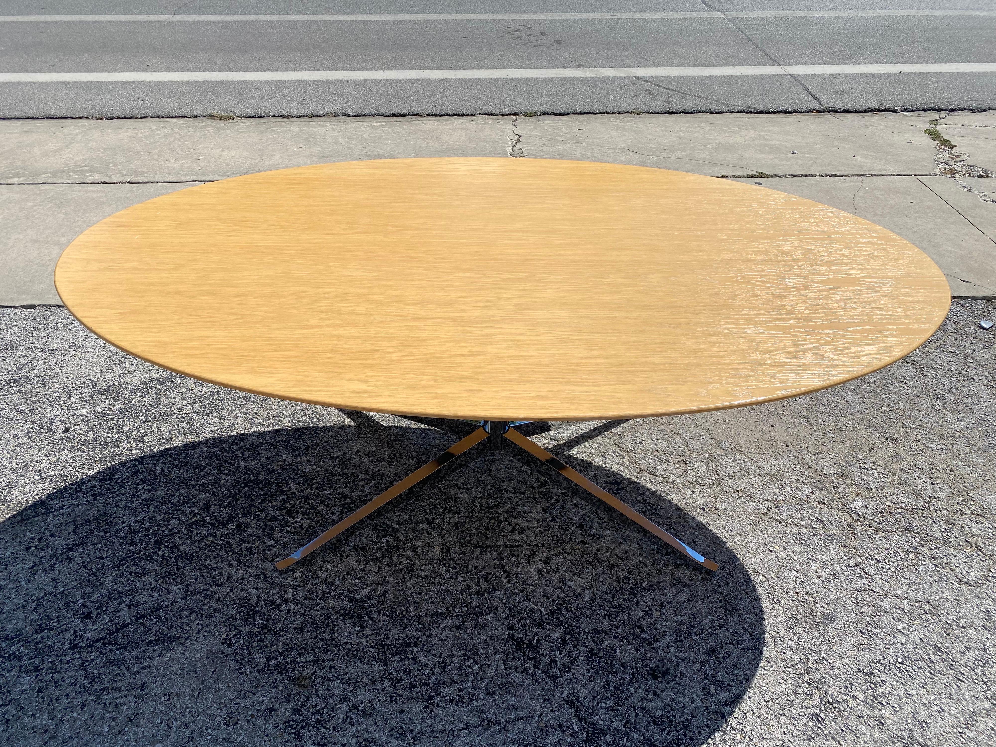 Iconic Mid-Century Modern dining table or conference table designed by Florence Knoll features an oak oval top and the classic chrome base. This mid-century dining table is in great vintage condition.