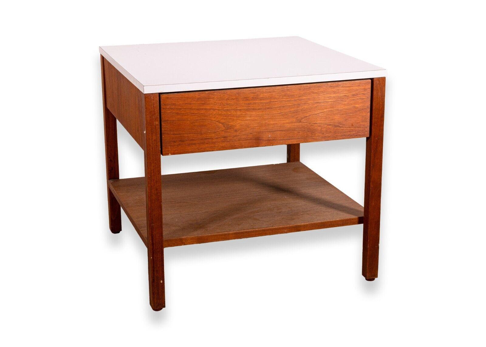 A mid century modern Florence Knoll walnut end table nightstand. This piece features a beautiful walnut wood construction with a table top. This piece has a single drawer with ample storage space, and also features a unique tissue box holder.