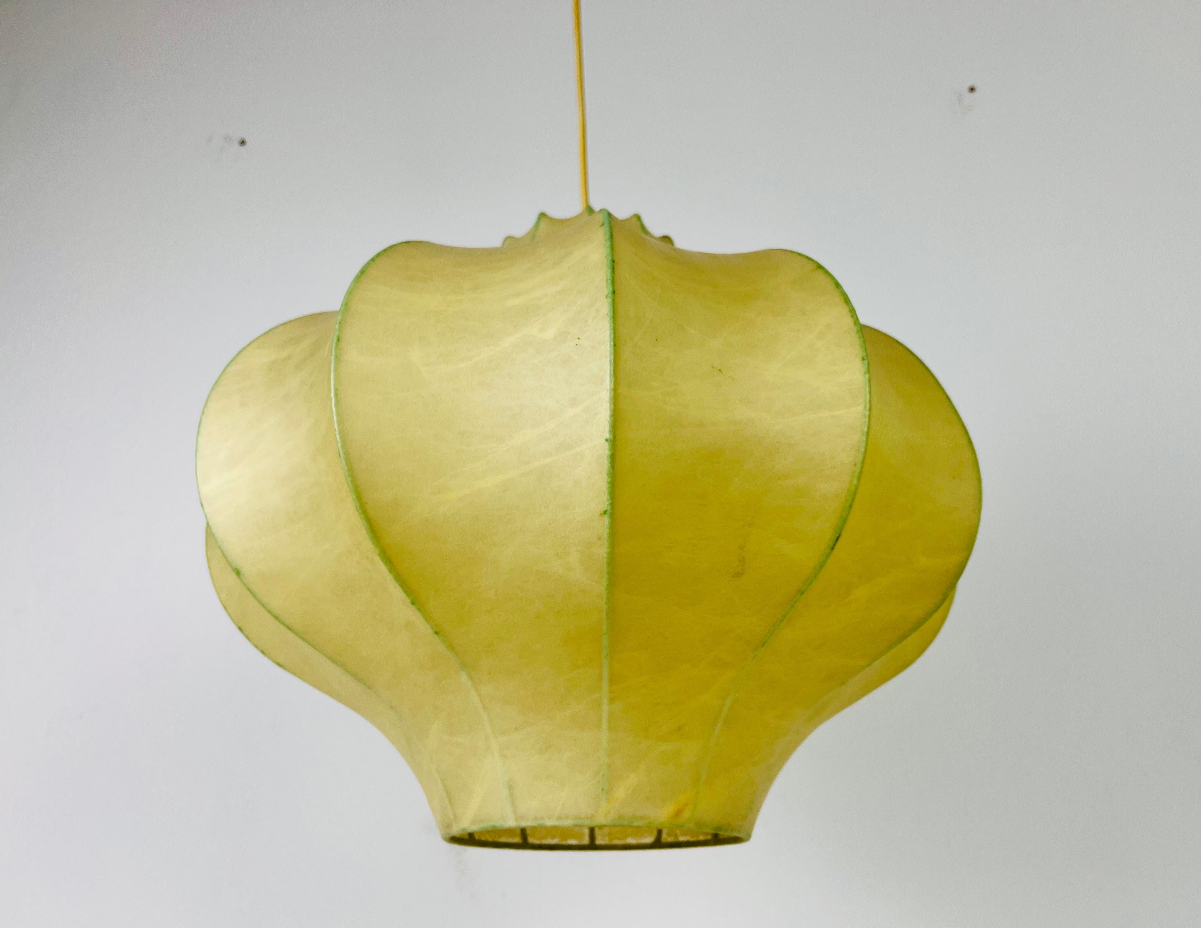 A cocoon pendant lamp made in Italy in the 1960s. The hanging lamp has been manufactured in the design of the lamps made by Achille Castiglioni. The lamp shade is of original cocoon and has an flower shape. 

Measures: 
Height: 36-72
