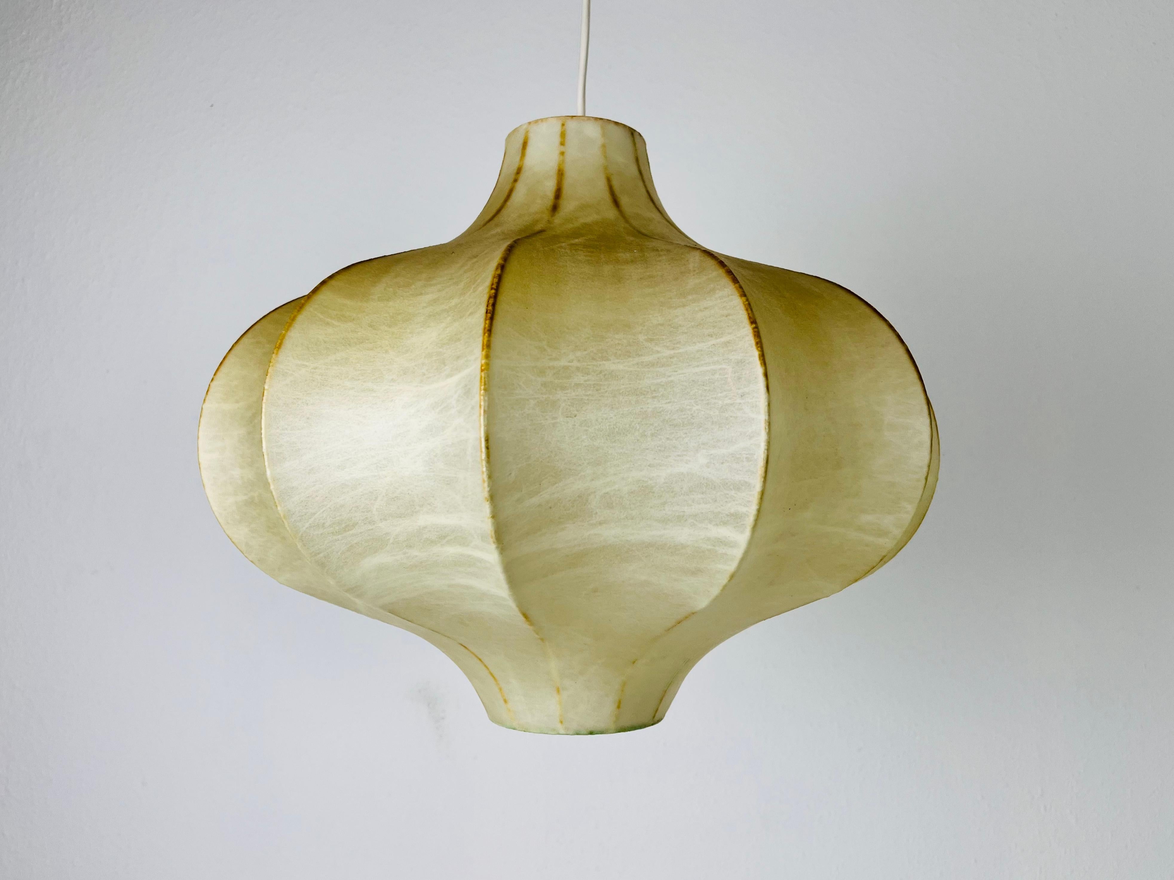 A cocoon pendant lamp made in Italy in the 1960s. The hanging lamp has been manufactured in the design of the lamps made by Achille Castiglioni. The lamp shade is of original cocoon and has an flower shape. 

Measures: 
Height: 36-65