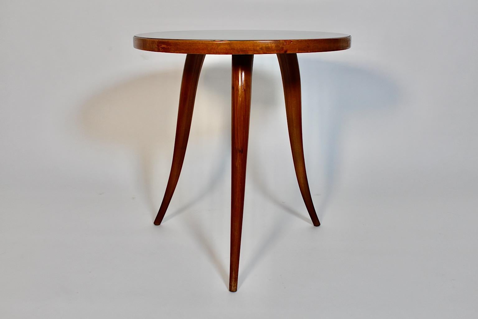 Tavolino vintage di forma circolare in noce e vetro verde, anni '40, attribuito a Gio Ponti.
Un favoloso tavolino da caffè in noce con quattro ( 4 ) piedi arrotondati e leggermente curvi, che si restringono gradualmente verso il basso.
La lastra di