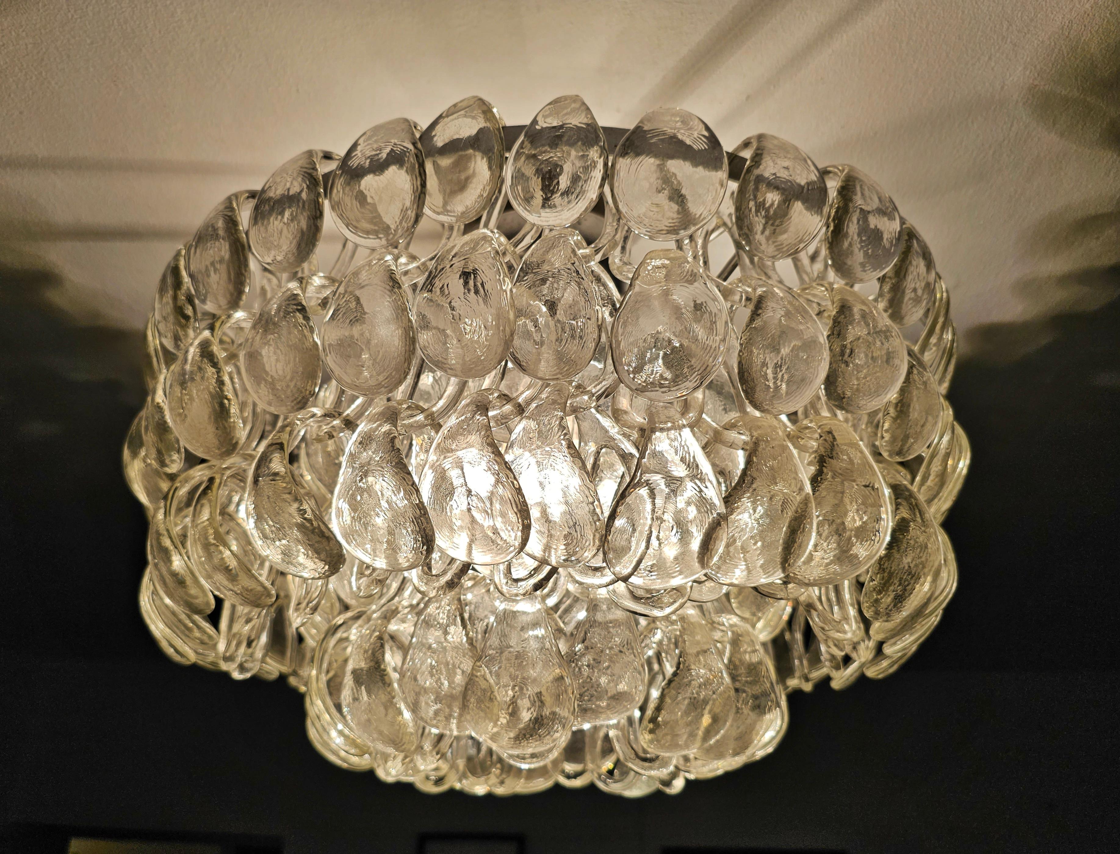 In this listing you will find a Mid Century Modern 2-tier Flush Mount called Giogali designed by Angelo Mangiarotti for Vistosi. The flush mount consist of a large number of Murano glass rings that attach one to another in the row of three, creating