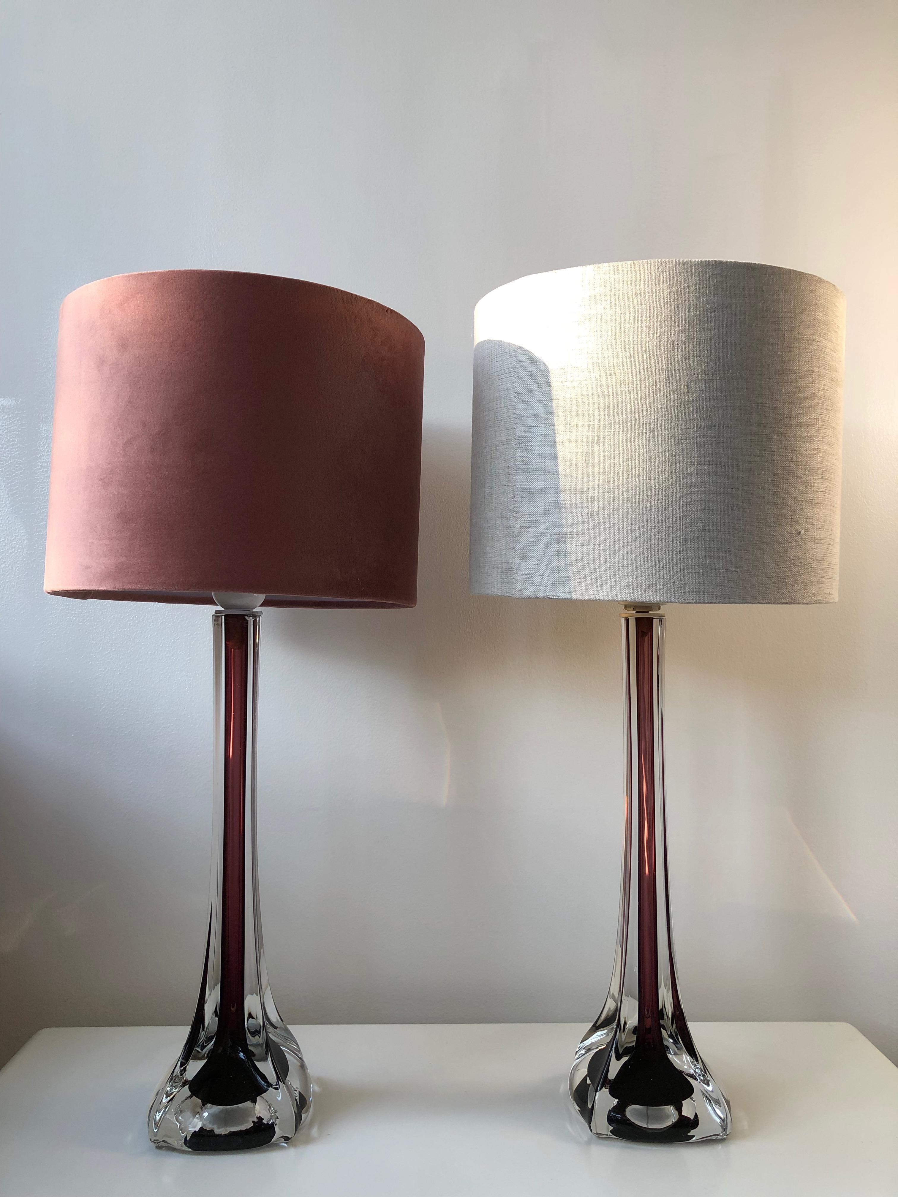 A pair of elegant Swedish Mid-Century Modern Sommerso style table lamps in hour glass form. Two tone glass in burgundy and clear glass in Murano Sommerso style. Pieces of art glass! 
Design by Swedish Flygsfors' Paul Kedelv and part of his