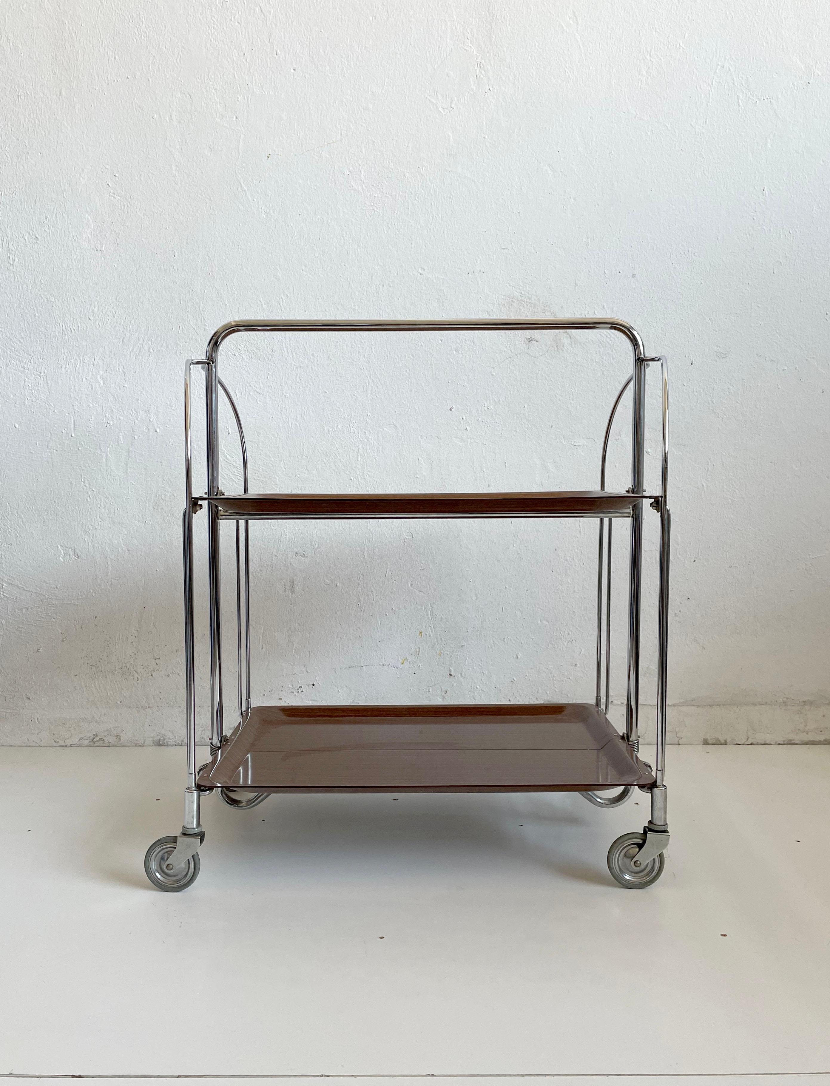 Vintage folding bar or serving cart from Germany
Manufactured in the 1970s

Brown melamine shelves and chrome structure. 

Multifunctional design
The trolley can be folded and therefore easily stored (great space saver)

It remains in very