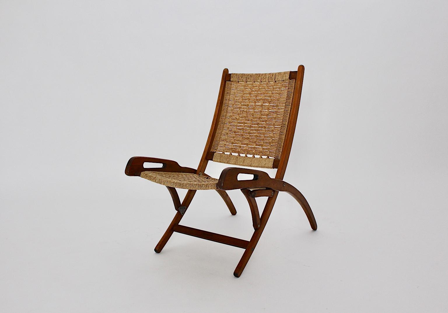 Mid-Century Modern vintage beech folding chair or lounge chair, which was made in 1960s in Italy. It consists of a solid brown stained and lacquered beechwood construction, while the seat and back were made of woven nylon ropes.
The folding chair is