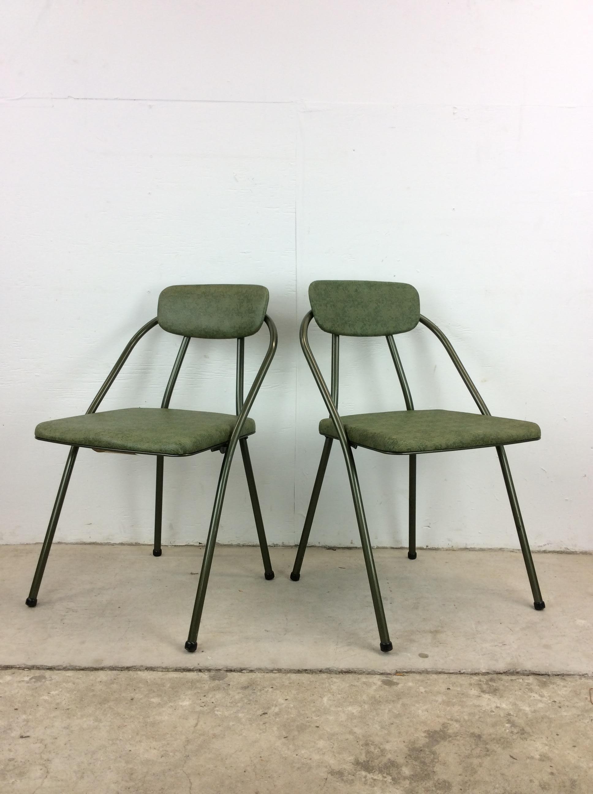 This pair of mid century modern folding chairs by Cosco features sleek modern look, vintage green upholstery, black painted metal frames and rubber capped feet.

Dimensions: 18w 15d 30h 17.5sh

Condition: Vintage green upholstery is in good
