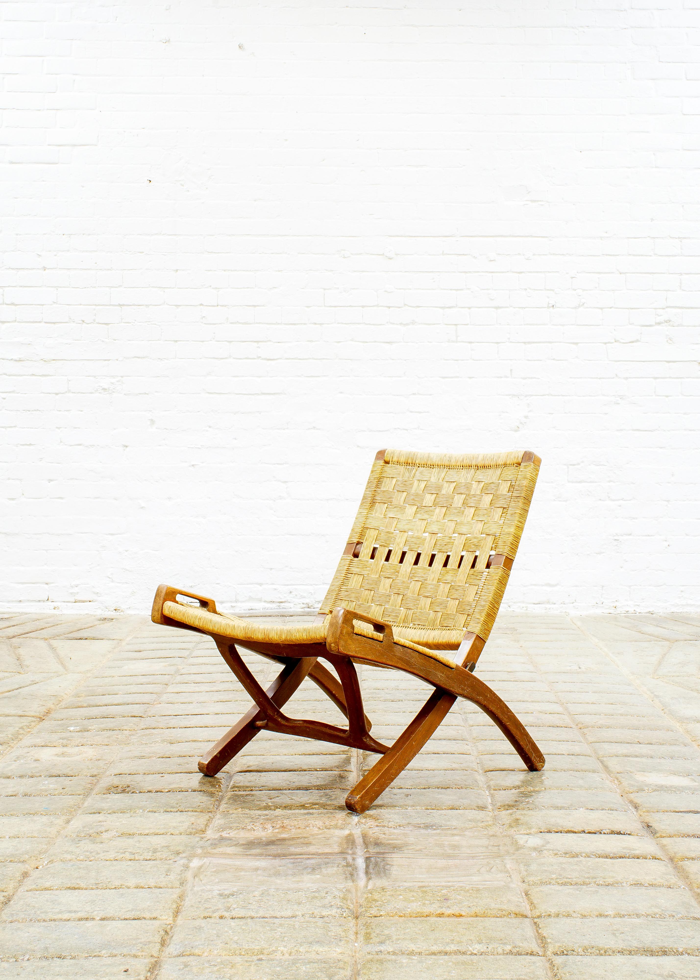 Fabulous folding armless lounge chair in oak and woven paper cord made after the JH512 midcentury chair by the famous Danish designer Hans Wegner. Nice brass fittings.
I believe this to be made in Yugoslavia, circa 1970.