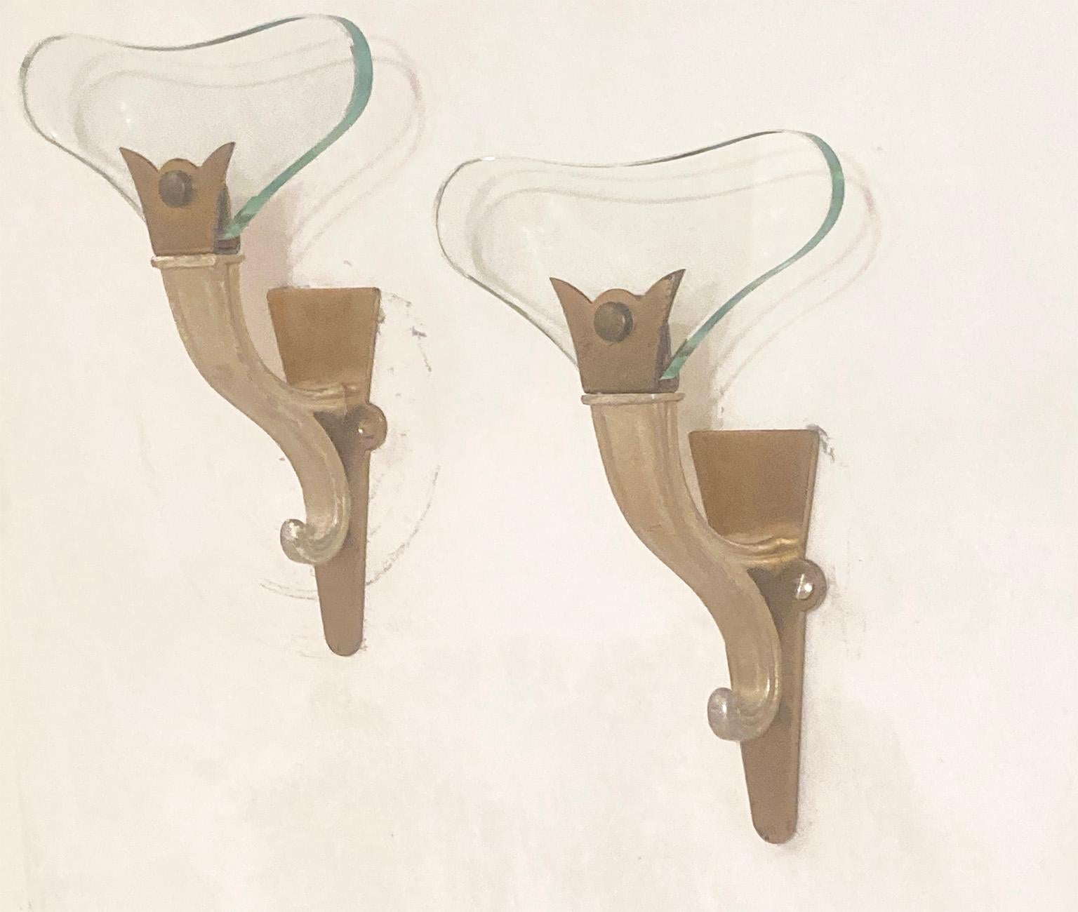 Pair of sconces with light green glasses mounted on brass structure partially white lacquered.
Due to their shape, they recall the coeval production of Fontana Arte.