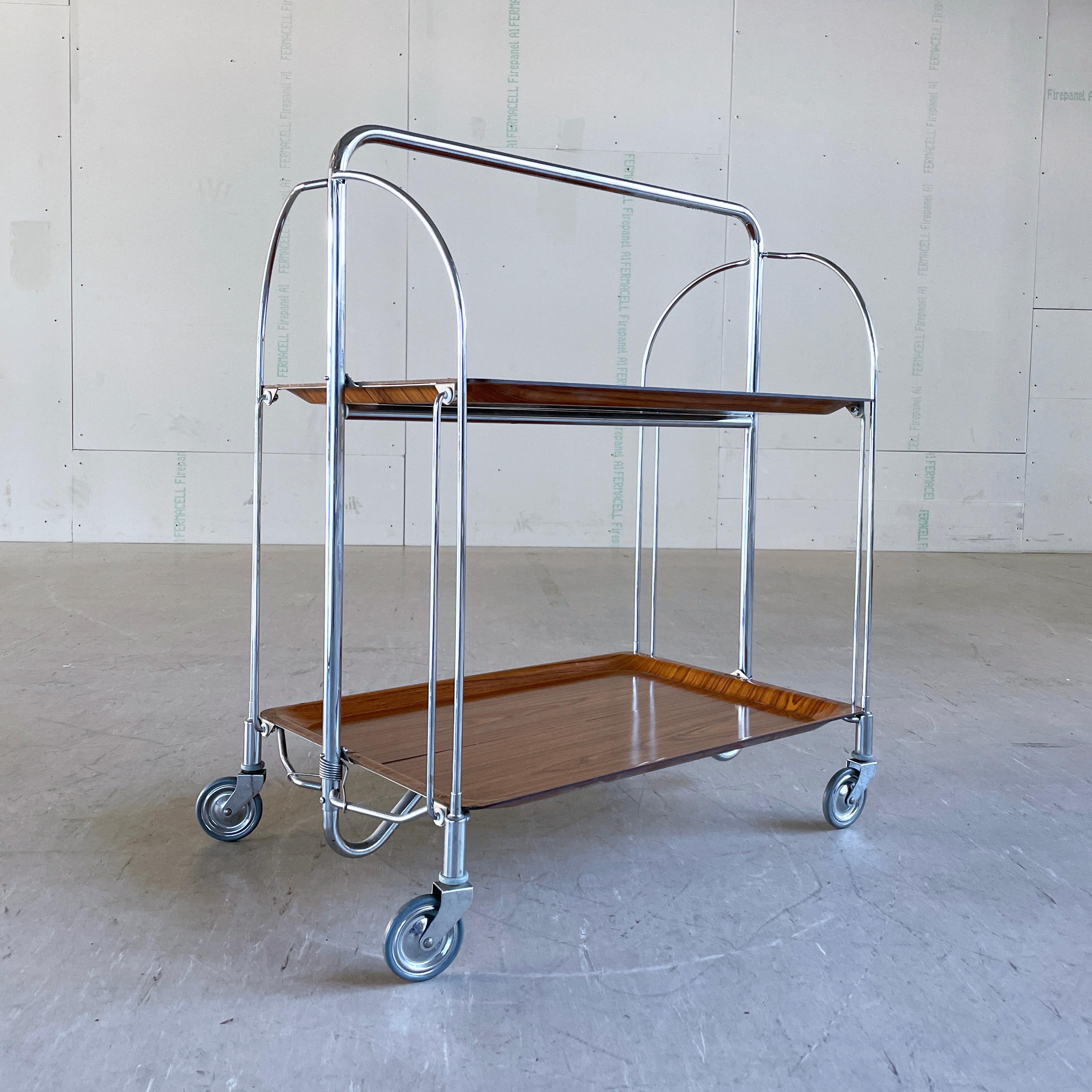 Carro plegable para servir/beber Bremshey Gerlinol 'Dinette', años 60. Producido por Bremshey AG, Sollingen, Alemania. Estructura metálica plegable con tableros de formica efecto madera. La solución perfecta para guardarla si tienes poco espacio,
