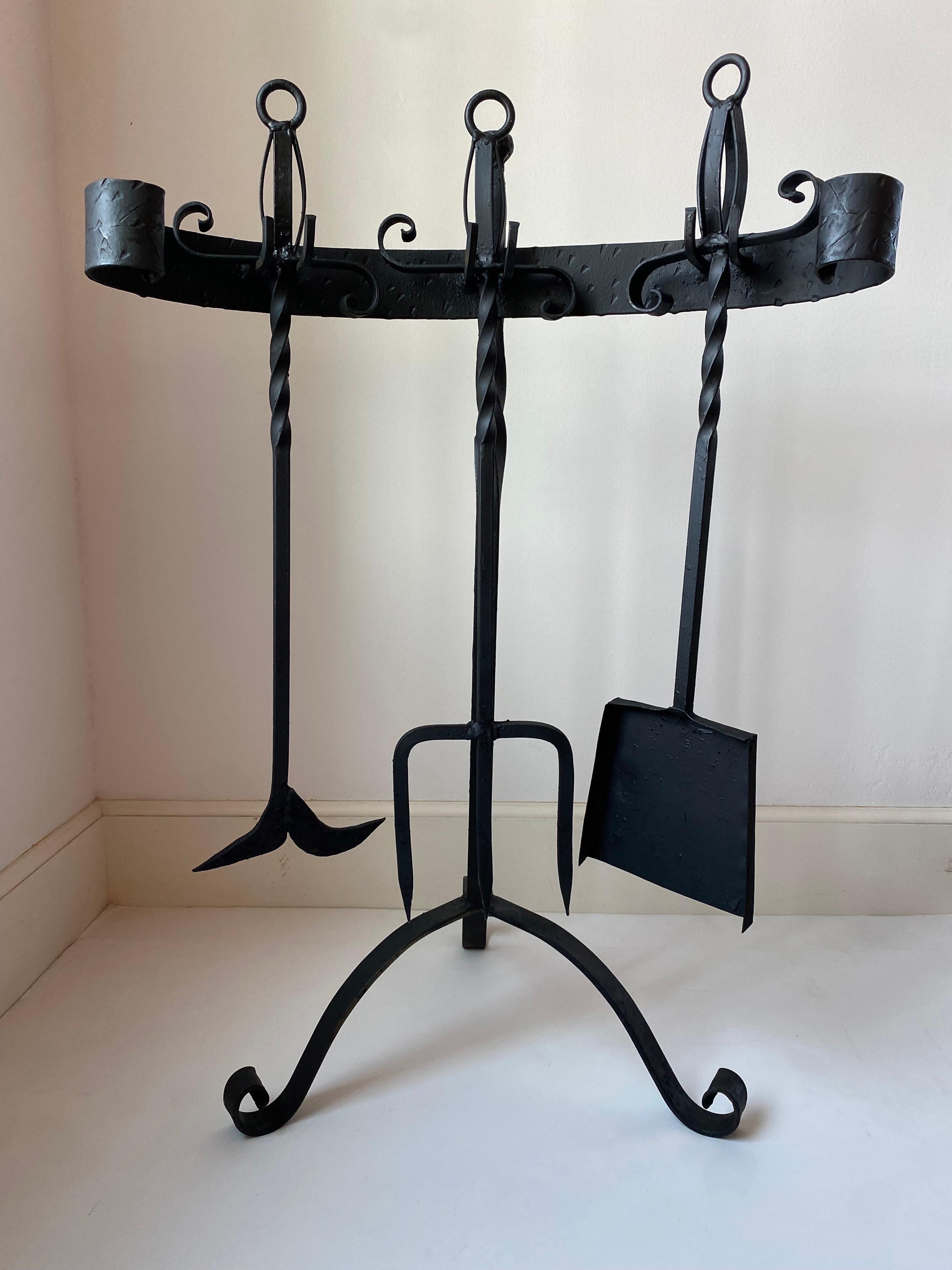 Skulpturale mexikanische Feuerwerkzeuge aus Schmiedeeisen, bestehend aus einer Schaufel, einem Schürhaken, einer Gabel und einem Halter, ca. 1970er Jahre. Der Feuerstahlhalter hat einen dekorativen Fuß und eine dekorative Rückseite, einschließlich