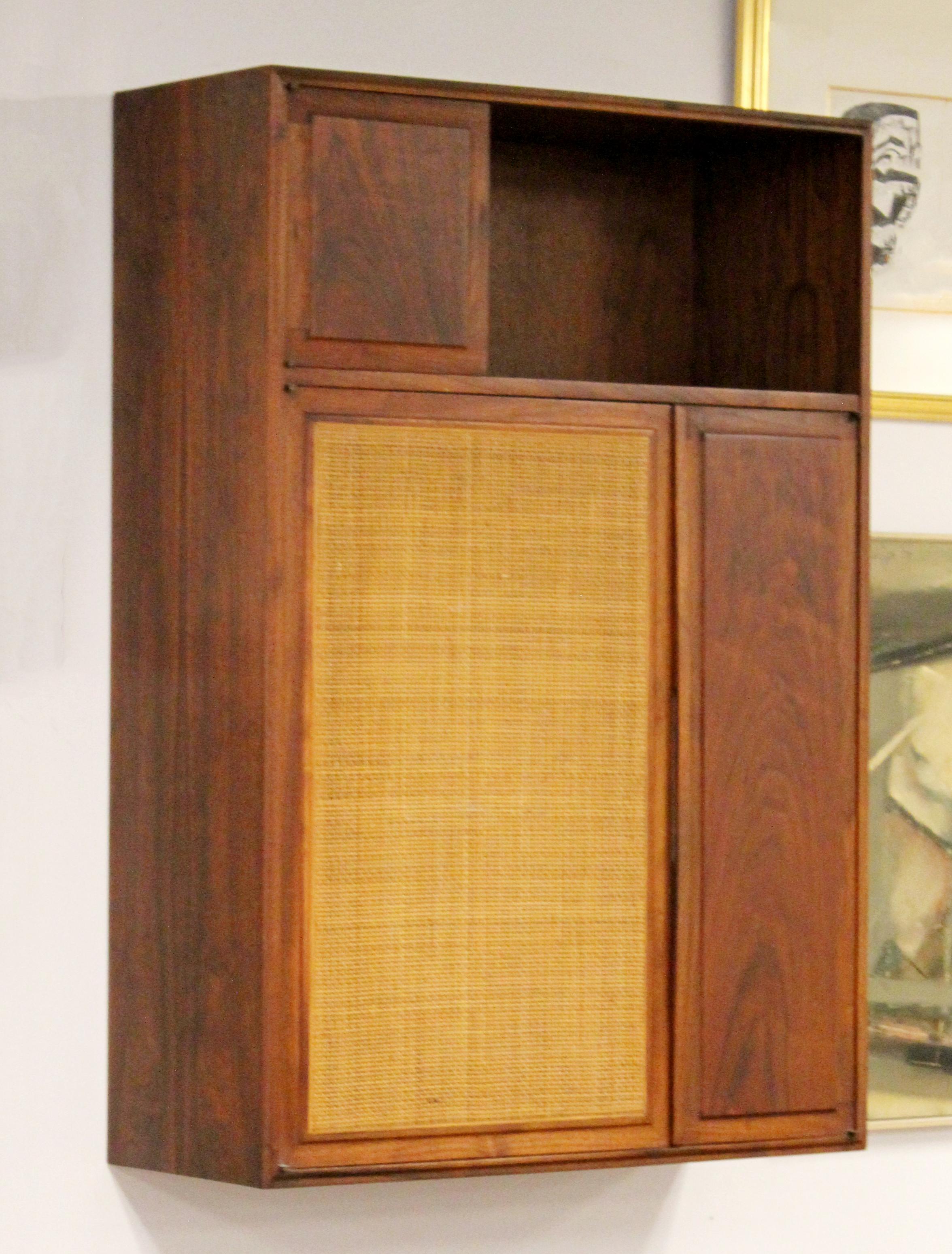 For your consideration is a fantastic, founders hanging cabinet wall unit, made of walnut wood and cane, circa 1960s. In excellent vintage condition. The dimensions are 33.5