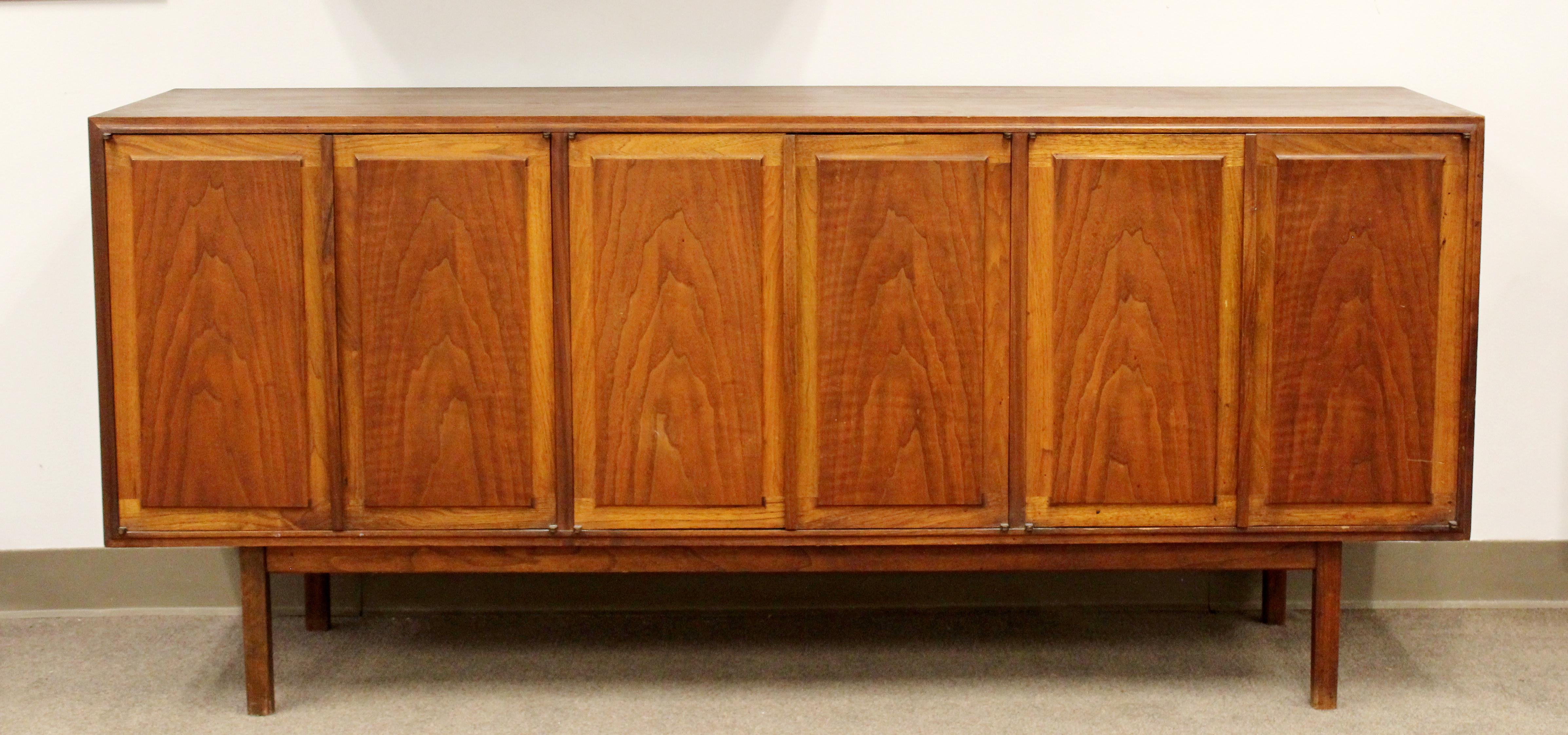 For your consideration is a marvelous, walnut wood credenza sideboard, with four doors, by Founders, circa 1960s. In very good vintage condition. The dimensions are 67