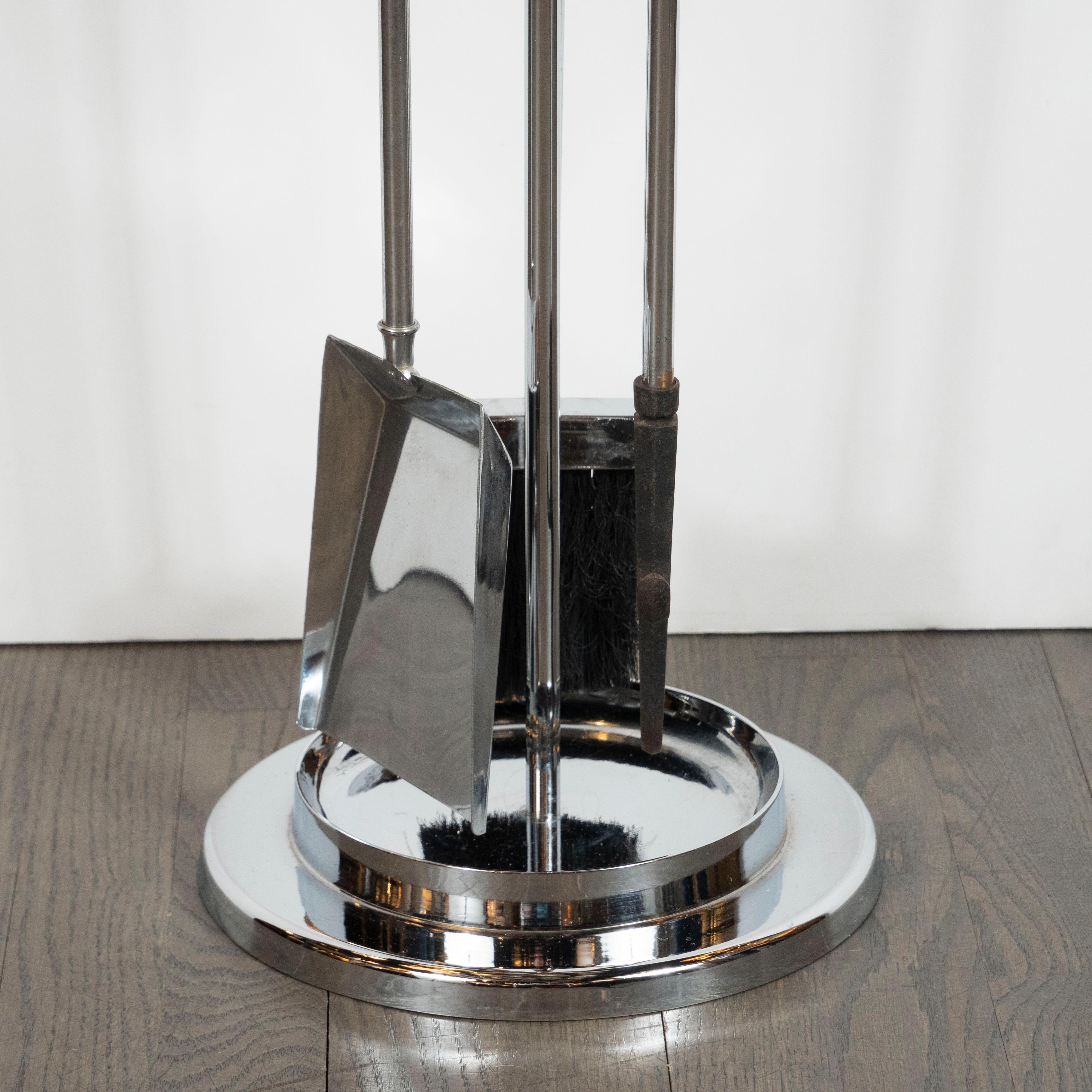 This refined Mid-Century Modern fireplace tool set includes stand, shovel, brush, and poker realized in lustrous polished chrome with translucent Lucite handles cut at a bias. The stand offers a circular base and a circular tier with indentations