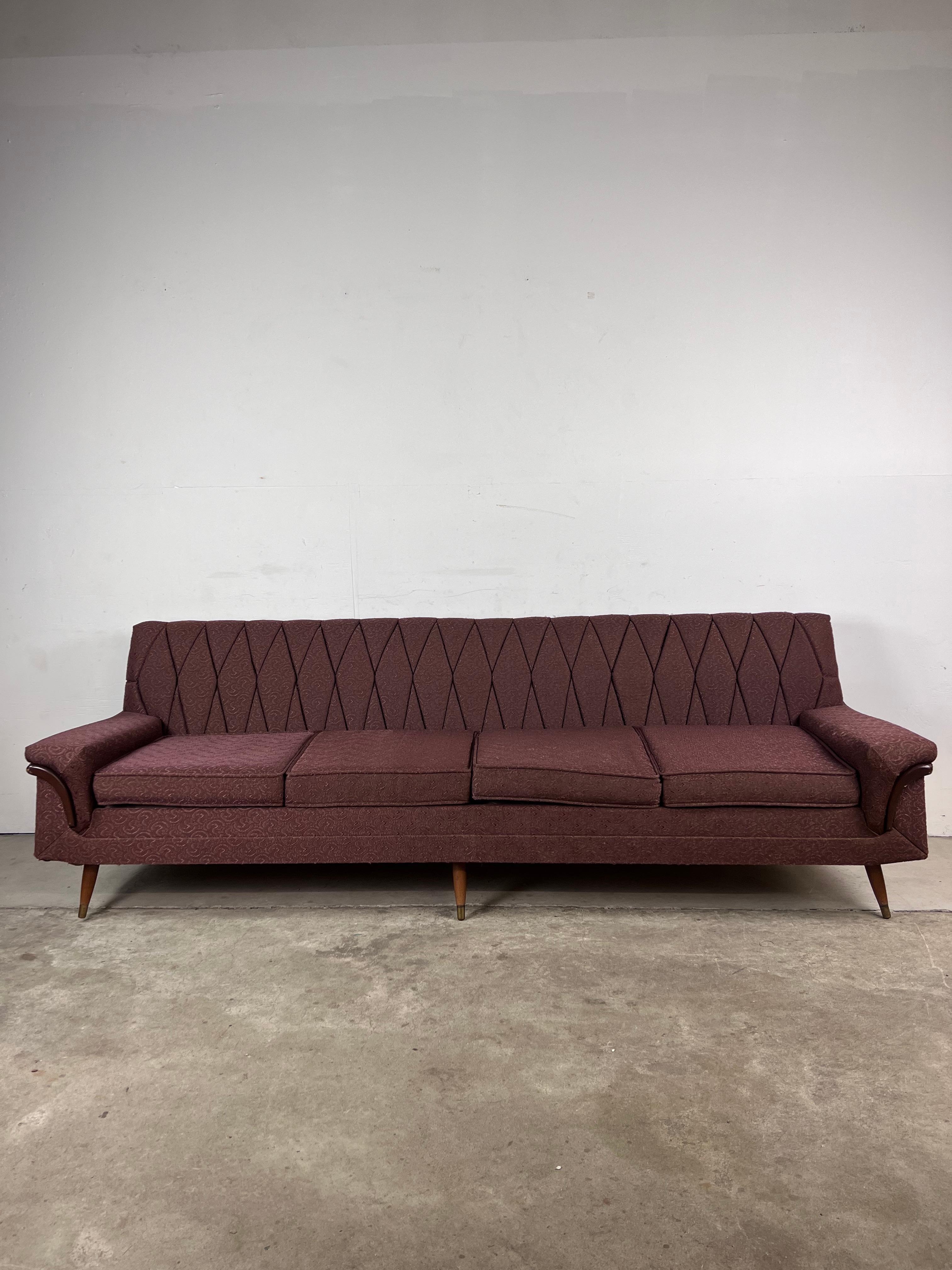 This mid century modern sofa features hardwood frame, original brown upholstery, scalloped seat back, removable cushions, broad armrests with walnut accents, and tapered legs with brass capped feet.

Matching lounge chair available separately.

