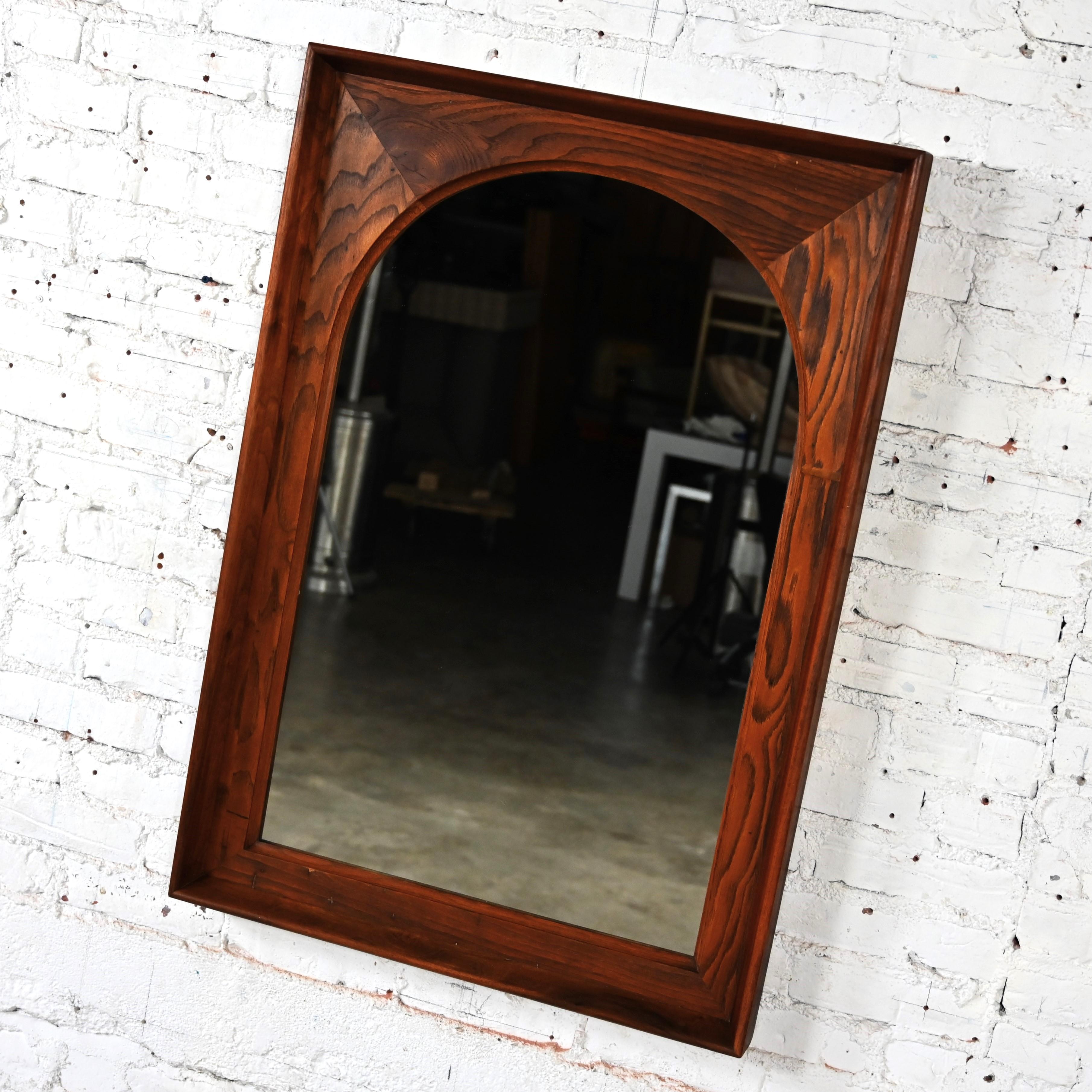 Magnifique miroir à arc encadré de style moderne du milieu du siècle dernier par Dillingham Manufacturing Company. Composé d'un miroir arqué entouré d'un cyprès rustique et d'une garniture en noyer. Byit, en gardant à l'esprit qu'il s'agit d'une