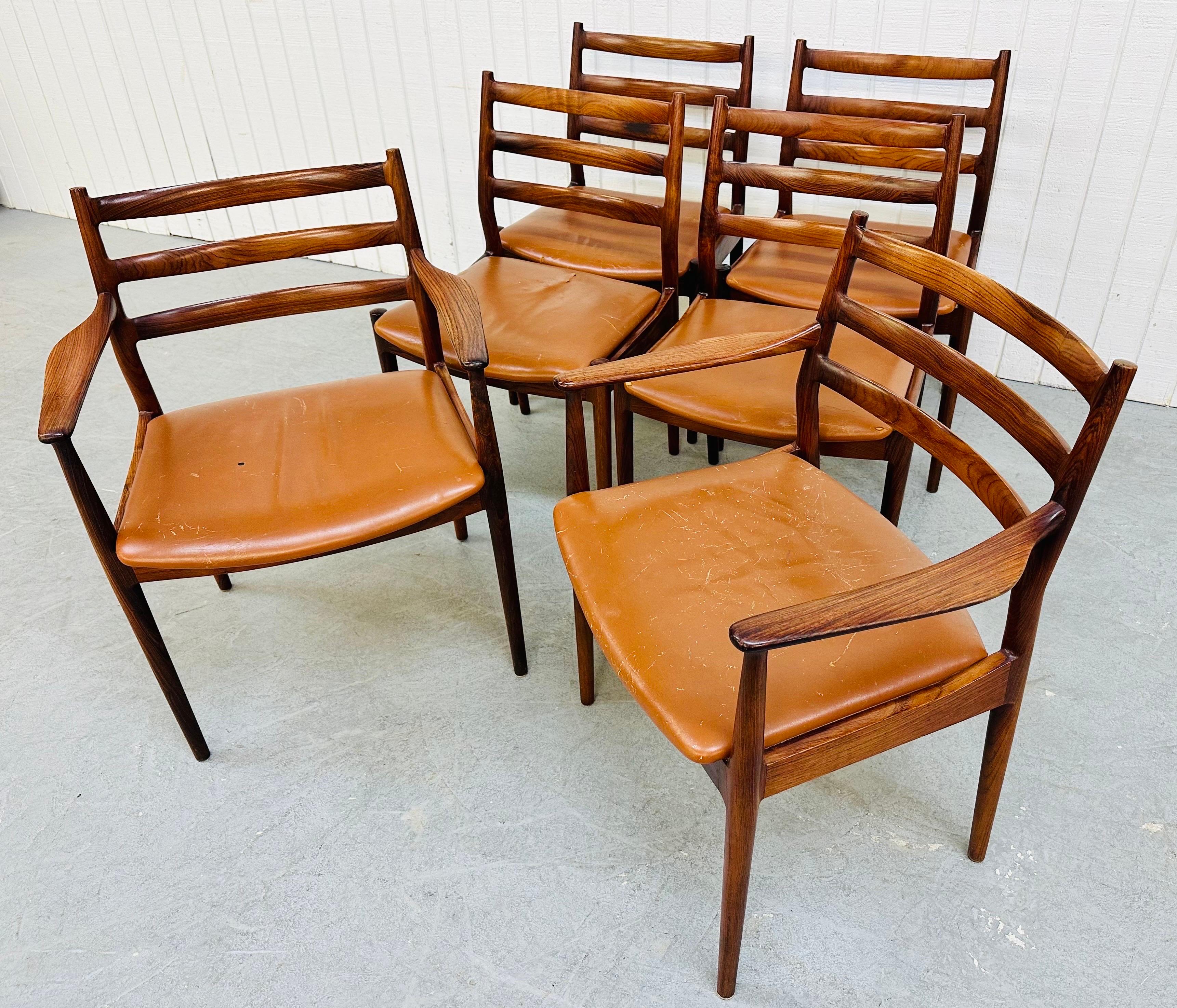 This listing is for a set of six Mid-Century Modern France & Son Danish Rosewood Dining Chairs. Featuring two arm chairs, four straight chairs, ladder backs, solid rosewood frames, original leather upholstery, and a beautiful rosewood finish. This