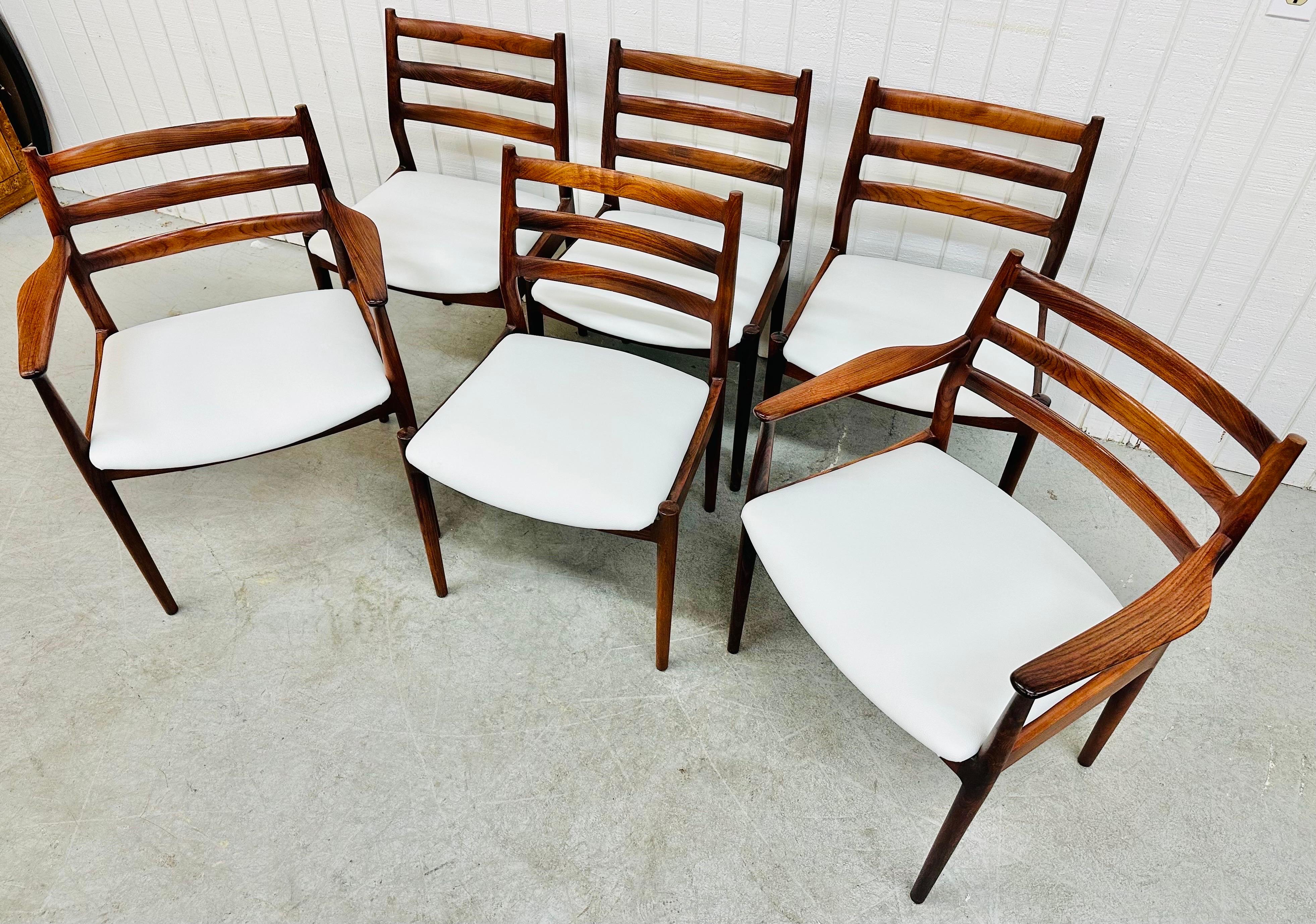 This listing is for a set of six Mid-Century Modern France & Son Danish Rosewood Dining Chairs. Featuring two arm chairs, four straight chairs, ladder backs, solid rosewood frames, new white vinyl upholstery, and a beautiful rosewood finish. This is