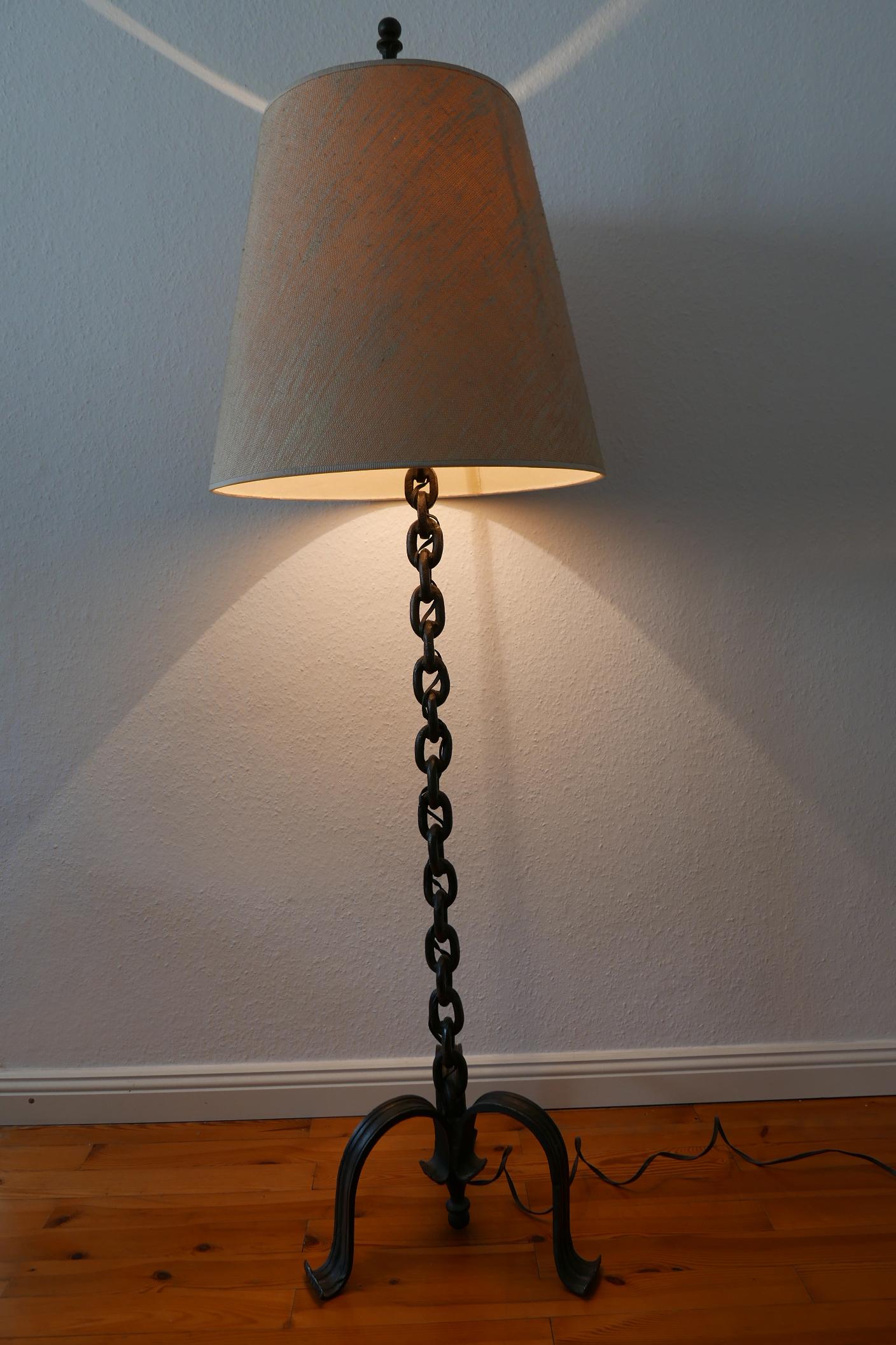 Pesada y decorativa lámpara de pie con cadena de hierro forjado de la Modernidad de Mediados de Siglo, al estilo de Franz West. Fabricado en Alemania, década de 1960.

Realizada en hierro forjado y yute, la lámpara de pie viene con 1 portalámparas