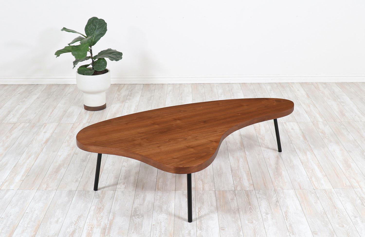 Vintage modern free-form coffee table designed and manufactured by Vista of California in the United States during the 1950s. Our minimalist Mid-Century Modern table features a beautiful and walnut top with an organic shape for a stunning grain