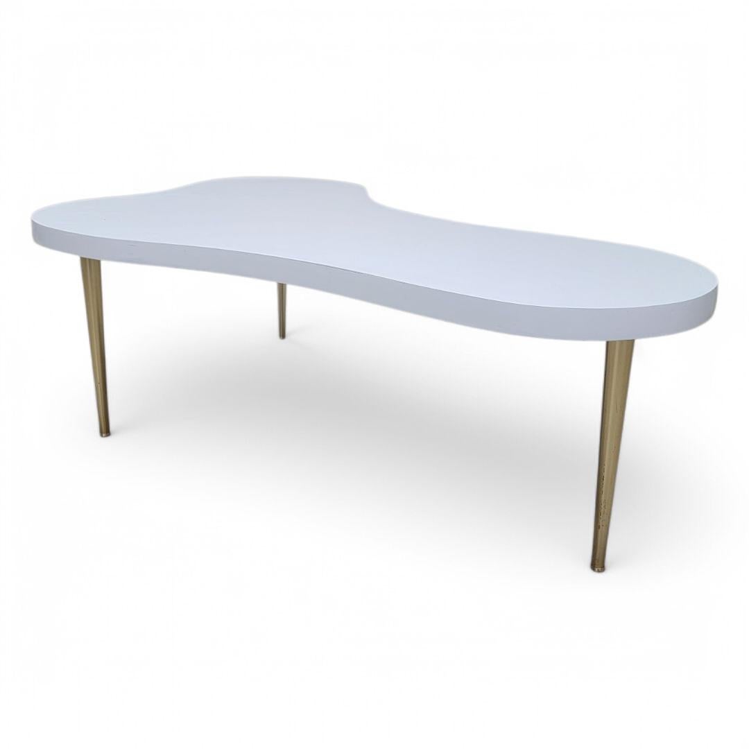 Mid Century Modern Free Form T.H. Robsjohn-Gibbings Brass Leg Cloud Coffee Table

Elevate your living space with the MCM Free Form T.H. Robsjohn-Gibbings brass leg cloud coffee table. This stunning piece features a sleek white laminate surface that