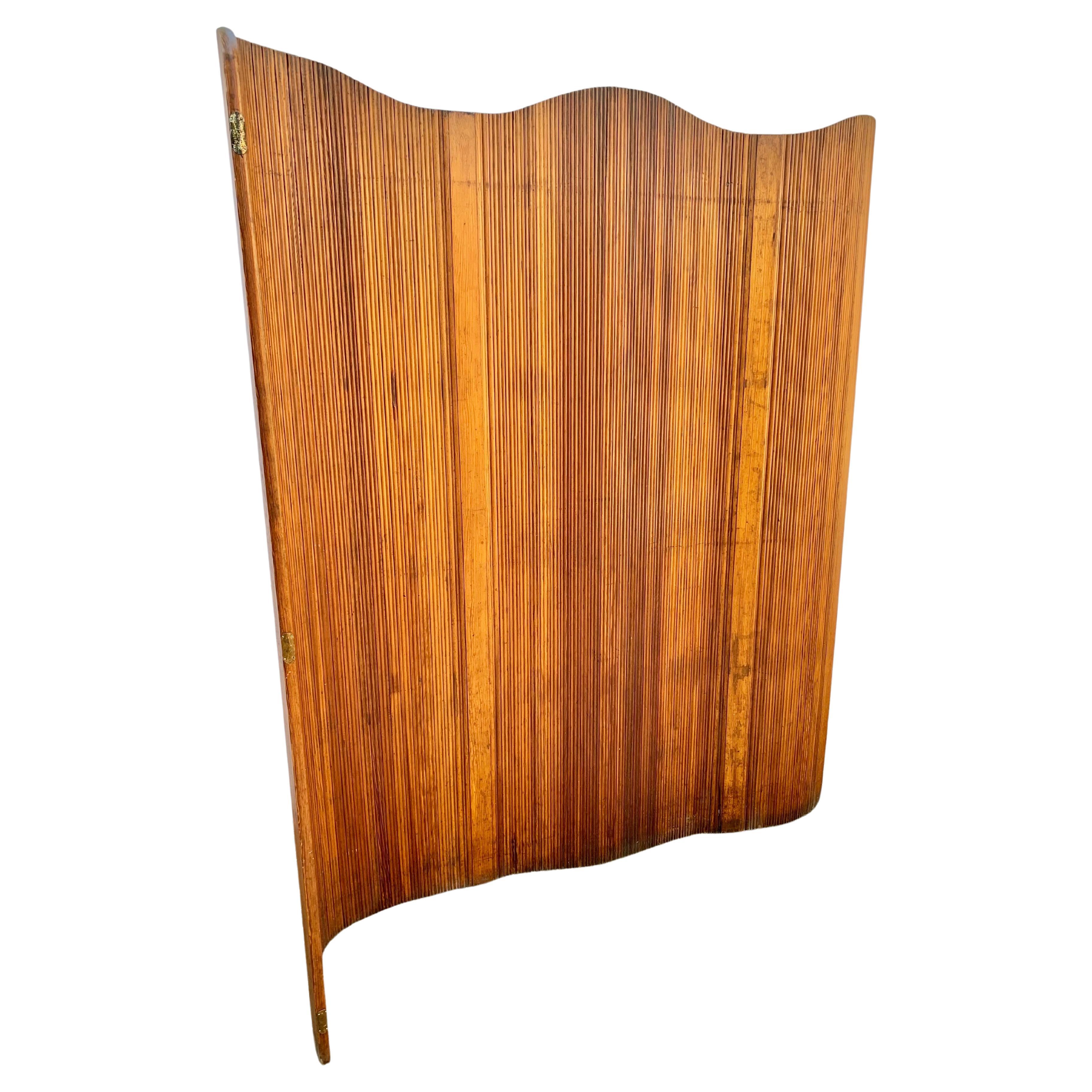 Found in France, this French Art Deco freestanding tambour room divider / folding screen in patinated heart pine was made by Baumann, Melun Paris. This flexible paravent is made out of strips of wood allowing the screen to stand freely, extend into