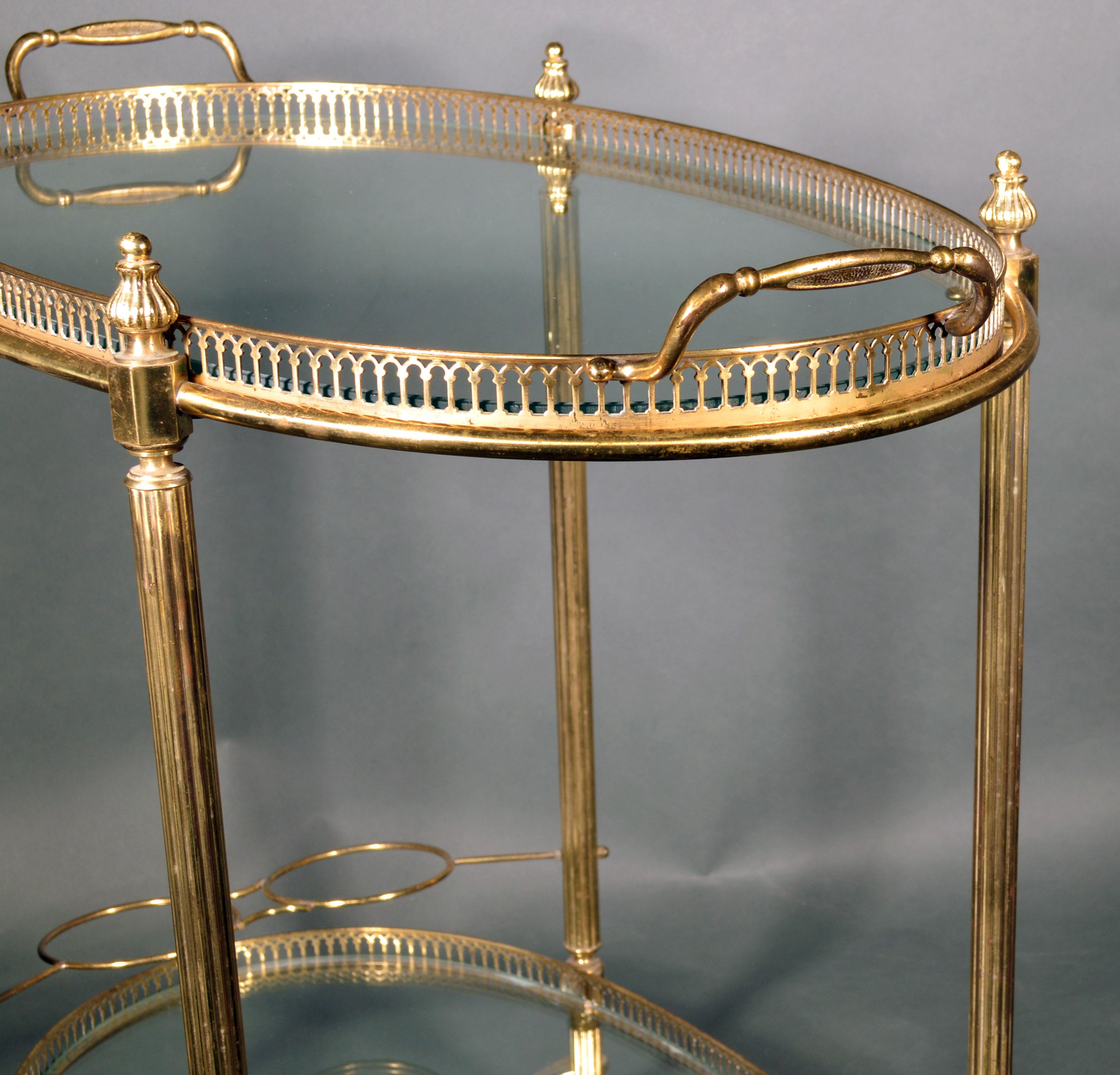 Mid-Century Modern French brass and glass bar cart
The 1950s.


The oval Mid-Century Modern gold brass metal bar cart has two glass shelves with a pierced brass gallery. The top shelf is actually a tray which is a removable serving tray with