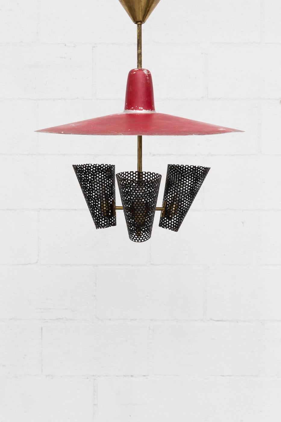 Great original enameled metal chandelier with three black enameled metal perforated shades with red enameled metal shade and brass hardware. Shade is in very original condition with visible wear and use.