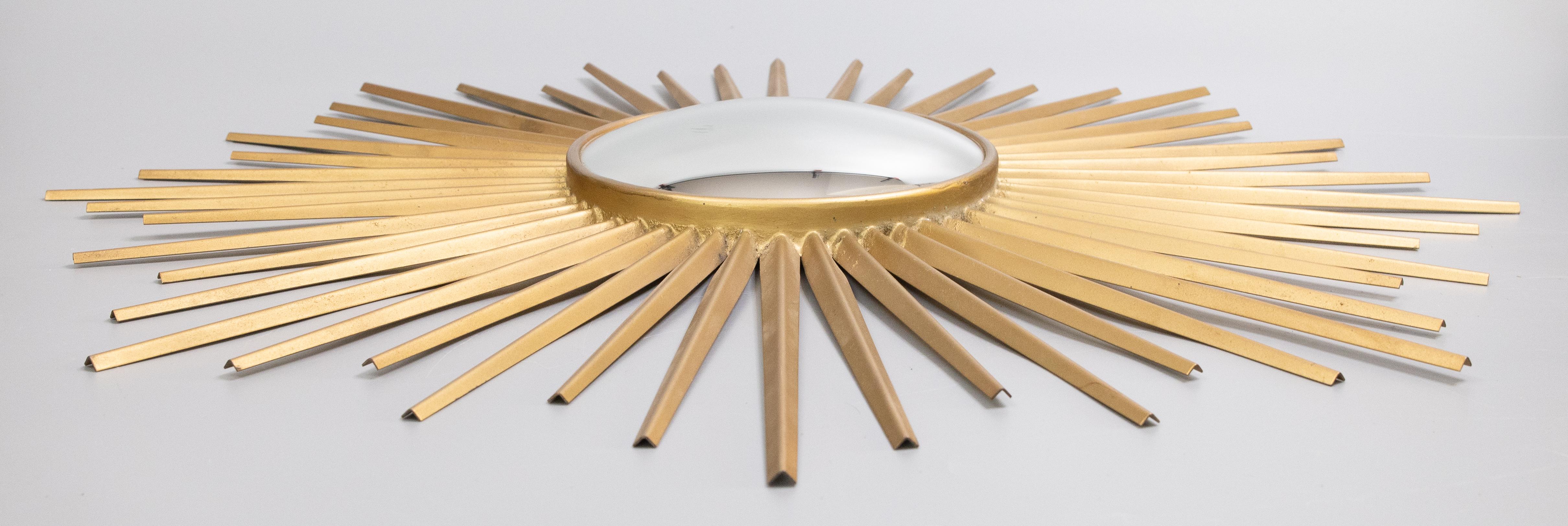 Eine atemberaubende Mid-Century Modern Französisch Chaty Vallauris Stil vergoldetem Metall sunburst Spiegel, um 1960. Der konvexe Originalspiegel und die Holzrückwand sind noch vorhanden. Keine Herstellermarke. Dieser stilvolle Spiegel hat glatte,