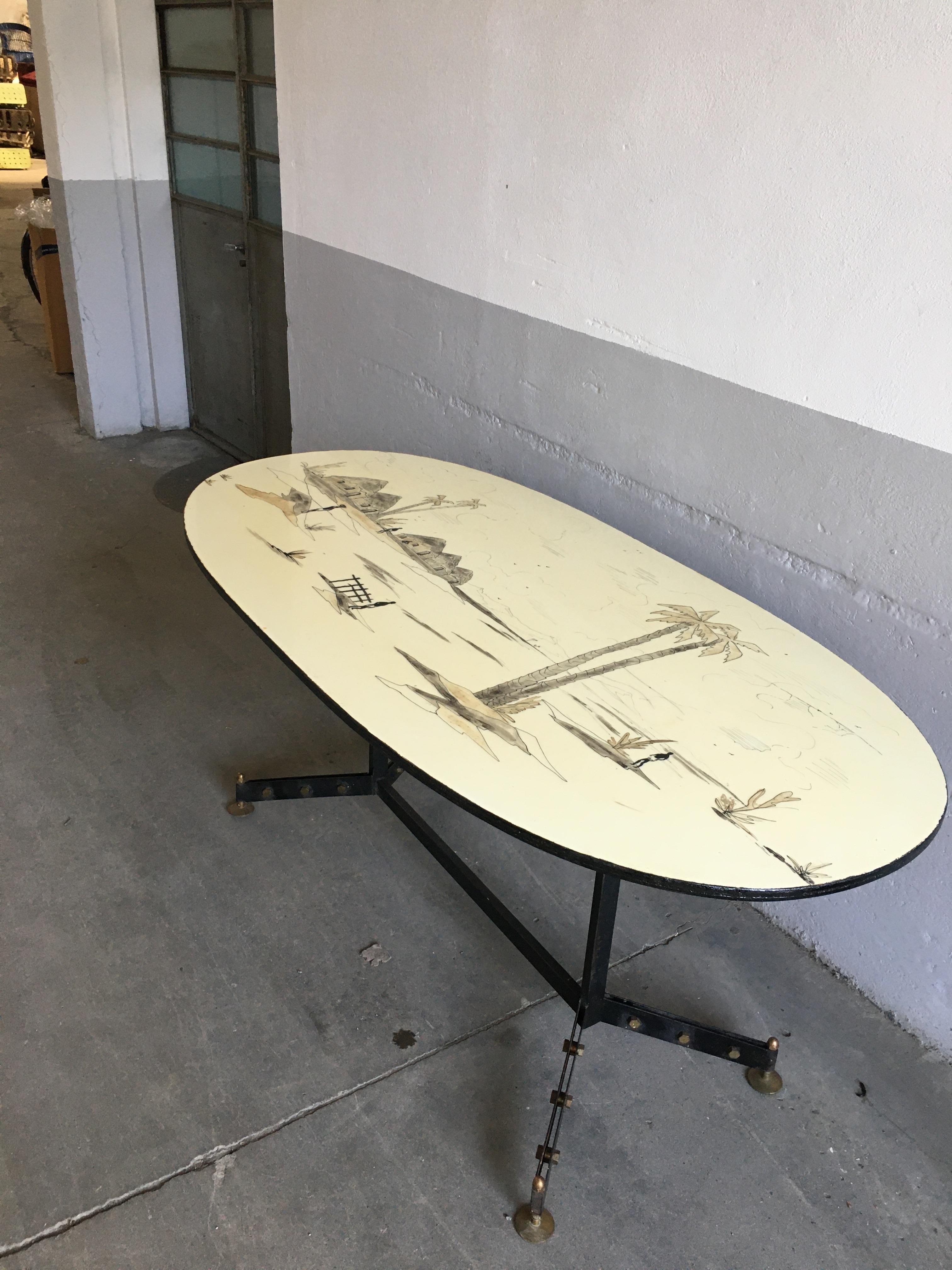 Mid-Century Modern French dining or center table with lacquered metal and brass legs and top decorated with African landscape.