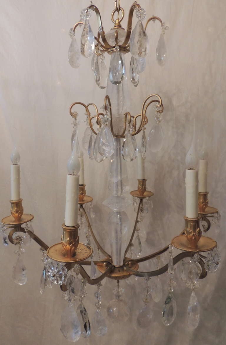 Un insolito lampadario francese a sei bracci in bronzo dorato e cristallo di rocca della metà del secolo scorso. L'albero centrale e tutte le altre parti in cristallo di questo fantastico apparecchio sono realizzate in cristallo di rocca.
