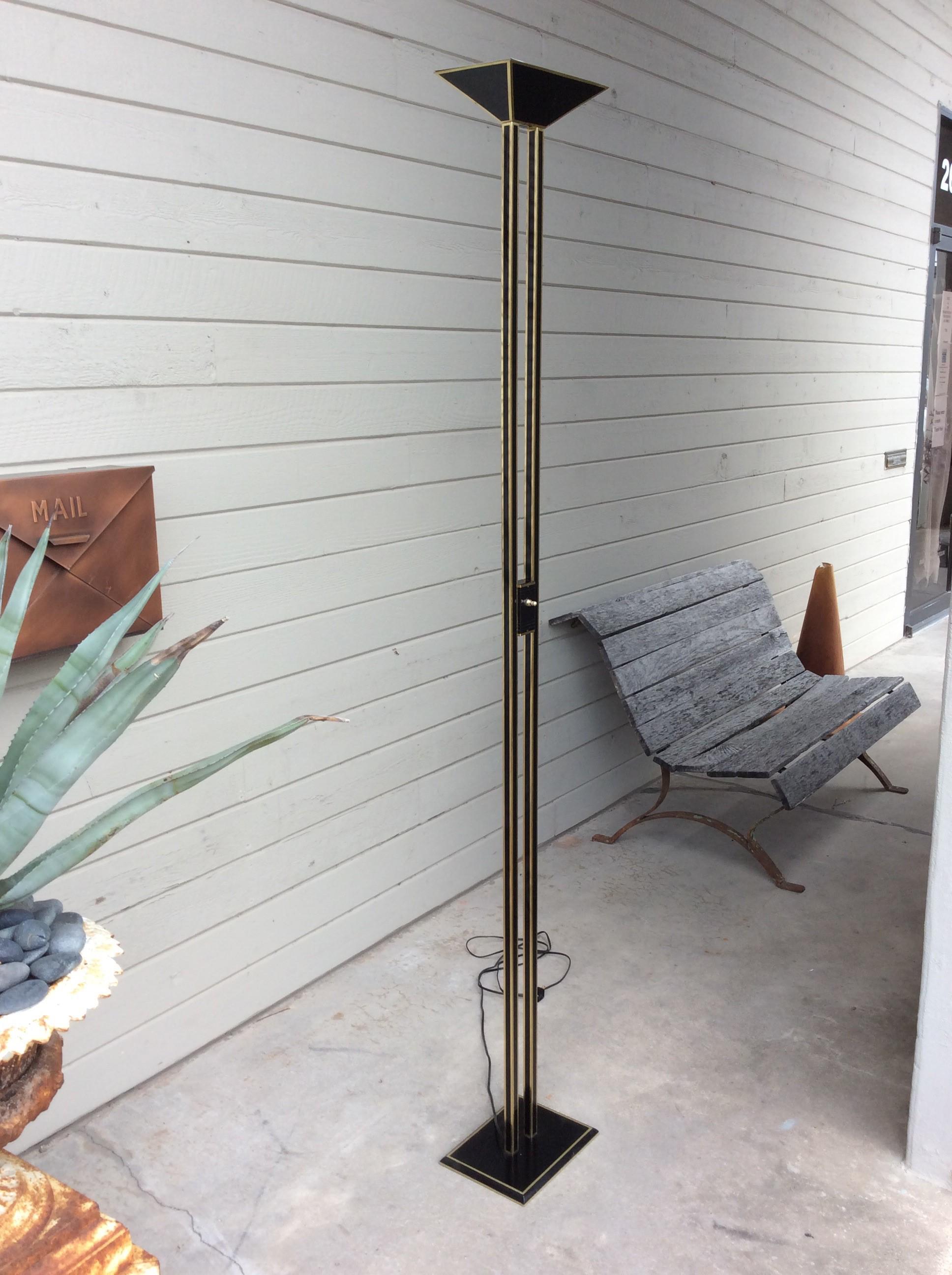 Found in the South of France, this Mid-Century Modern French Halogen Floor Lamp is constructed of metal in black with brass accents. The rectangular uplight rest on two columns that support the on and off switch and is attached at the bottom with a